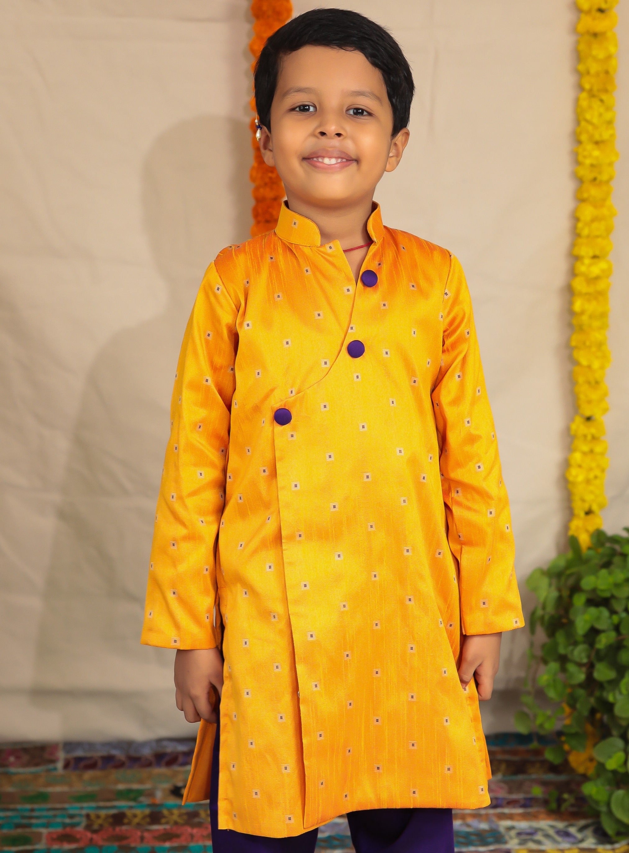Mango coloured raw silk kurta and Purple cotton silk salwar set.Kurtas with collar or Angrakha pattern teamed with salwar are the best choice for any festive occasion for boys. They are Trendy, Easy to wear and comfortable to carry.