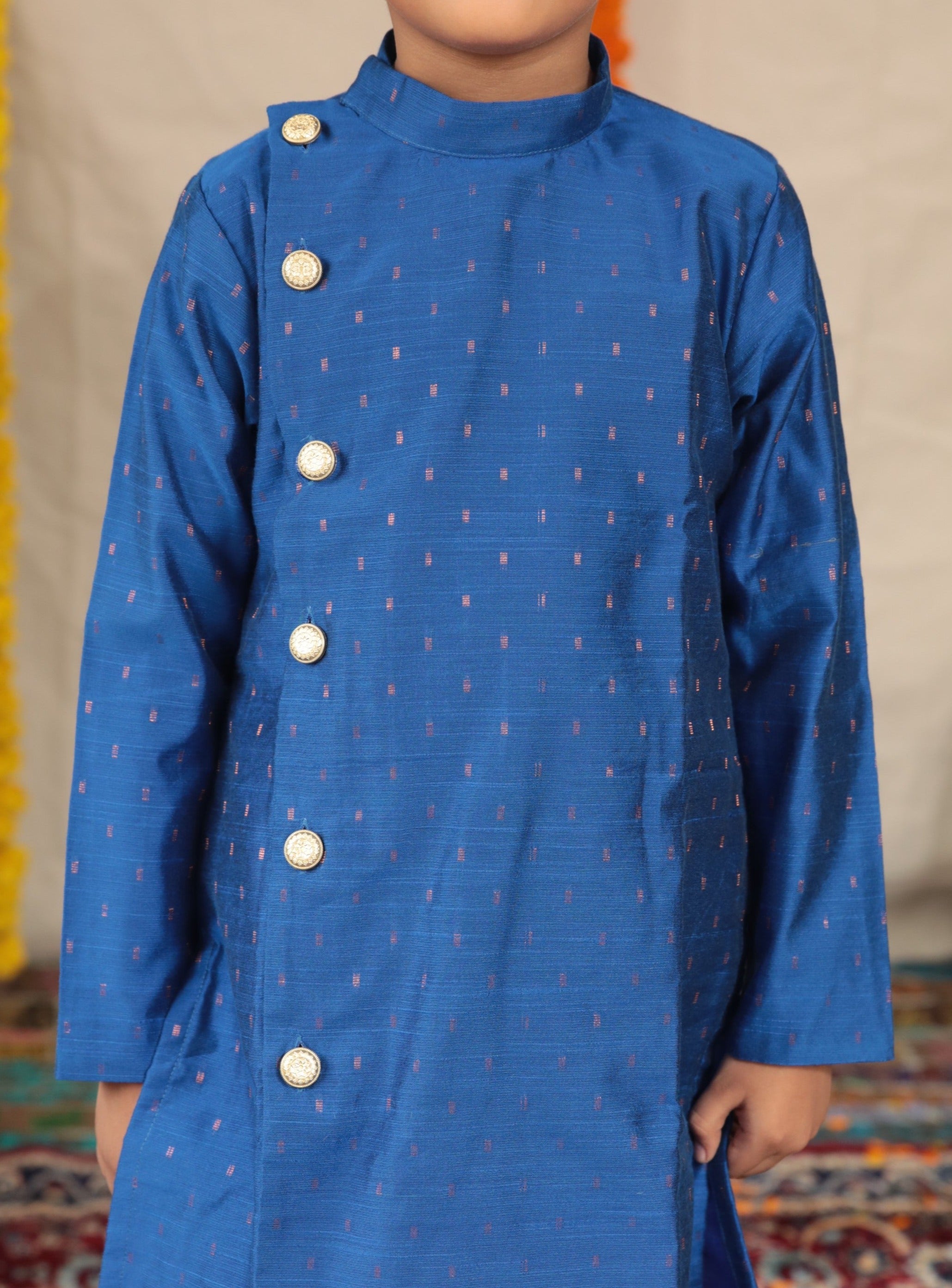 Royal blue pine silk Bandh Gala kurta with side placket and carrot pink cotton silk salwar set.Kurtas with collar or Angrakha pattern teamed with salwar are the best choice for any festive occasion for boys. They are Trendy, Easy to wear and comfortable to carry.