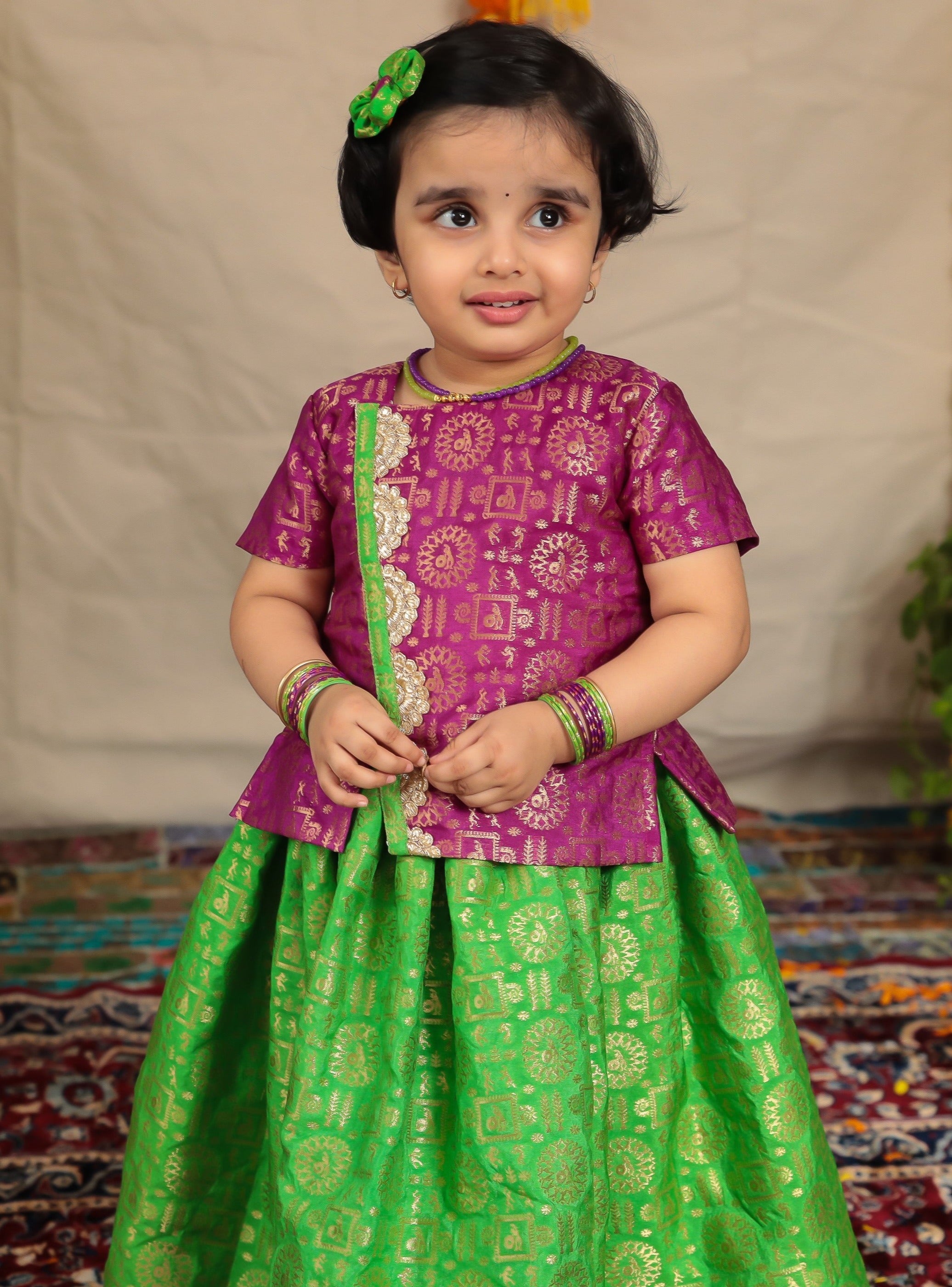 Parrot green brocade parkar and purple highlight teamed with purple brocade overlap pattern polka.Let your princess be as comfortable as in her casuals with carefully designed & crafted Comfort Ethnic Wear by Soyara Ethnics.Keep her fashion quotient high with timeless patterns, vibrant combinations and royal textiles.