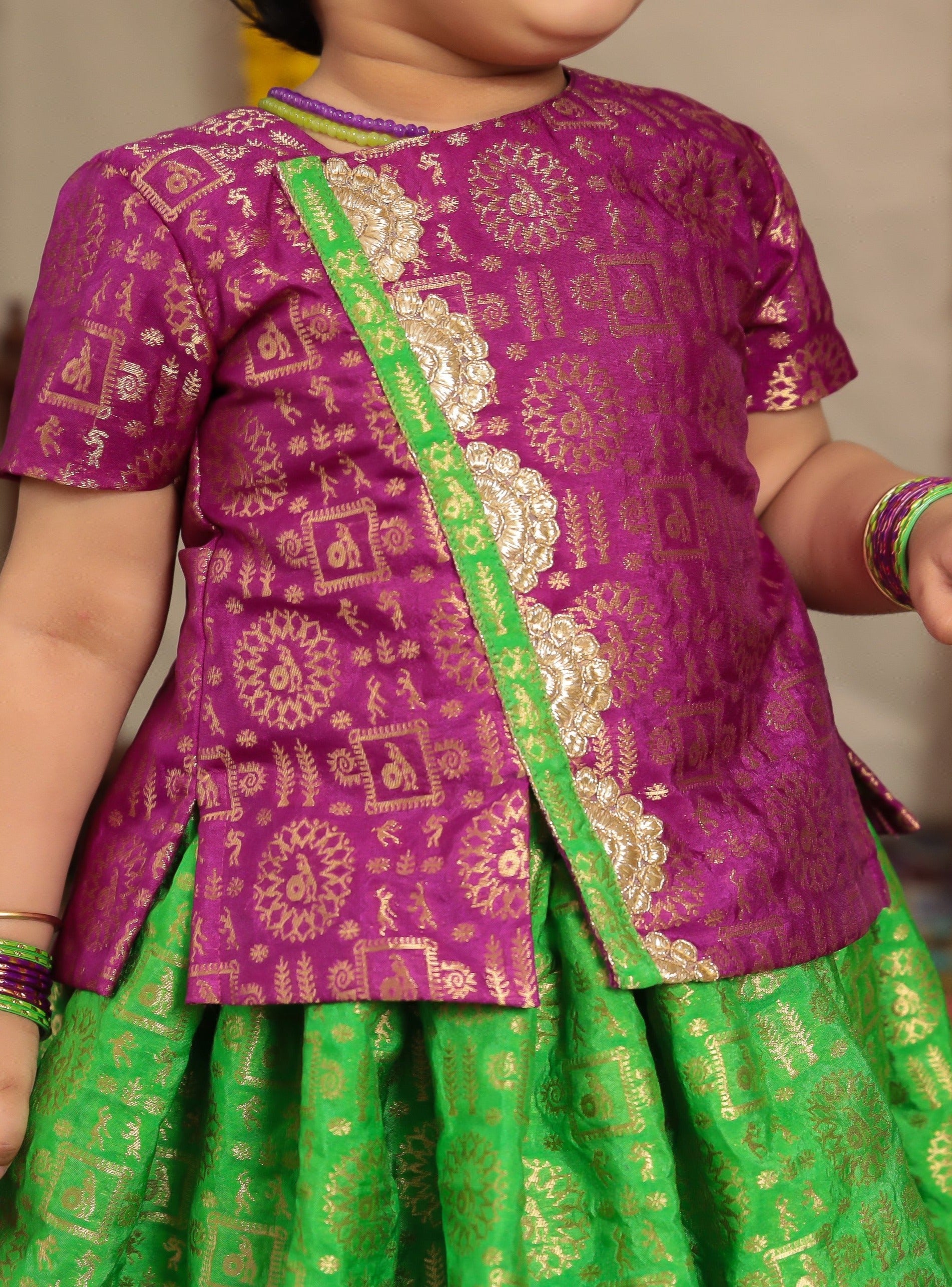 Parrot green brocade parkar and purple highlight teamed with purple brocade overlap pattern polka.Let your princess be as comfortable as in her casuals with carefully designed & crafted Comfort Ethnic Wear by Soyara Ethnics.Keep her fashion quotient high with timeless patterns, vibrant combinations and royal textiles.