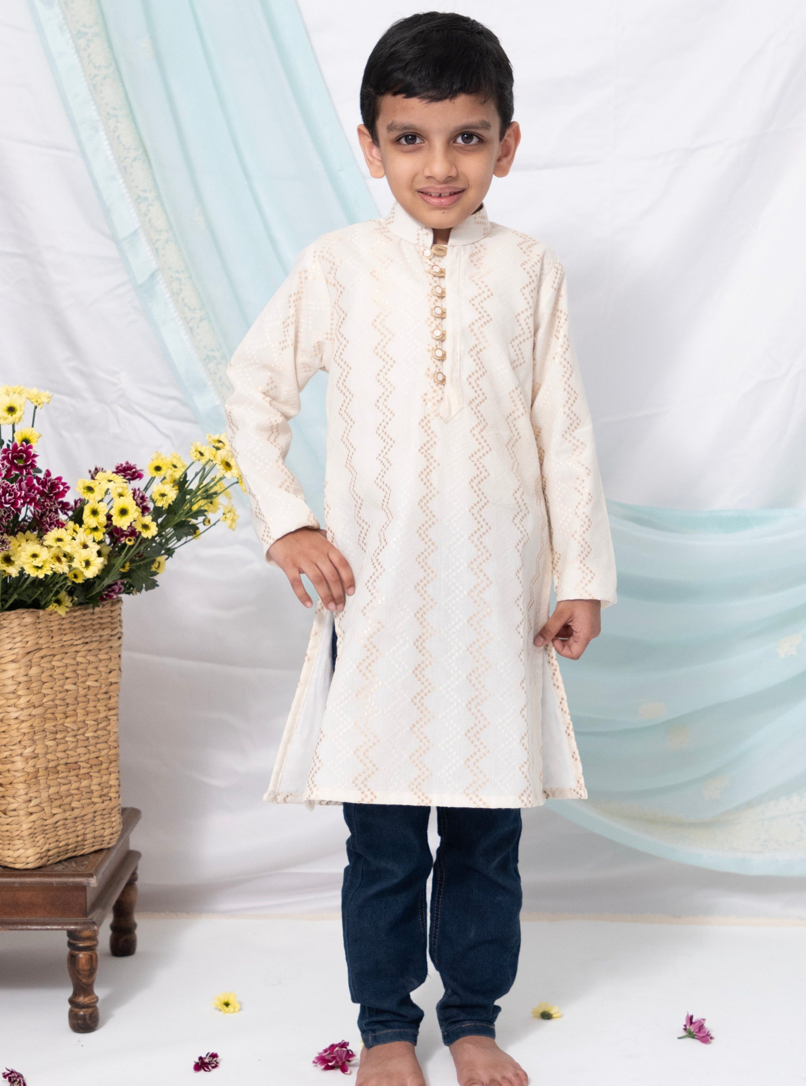 Off white khadi stand collar kurta with zigzag jari design for Boys.Kurtas with collar or Angrakha pattern teamed with salwar are the best choice for any festive occasion for boys. They are Trendy, Easy to wear and comfortable to carry.