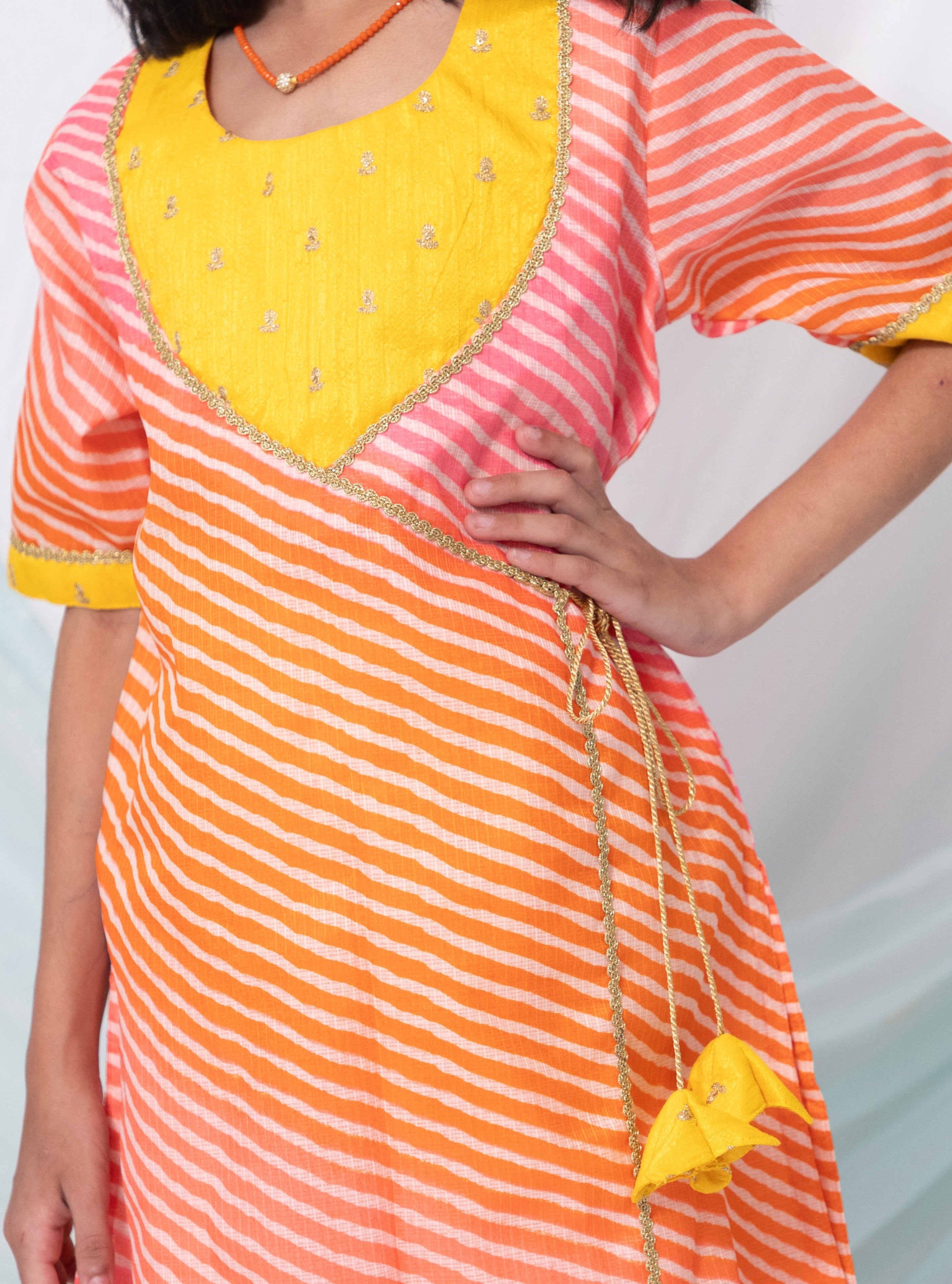 Pink and orange leheriya kotta chanderi kurti with yellow raw silk sequined yoke for Girls.Let your princess be as comfortable as in her casuals with carefully designed & crafted Comfort Ethnic Wear by Soyara Ethnics.Keep her fashion quotient high with timeless patterns, vibrant combinations and royal textiles.