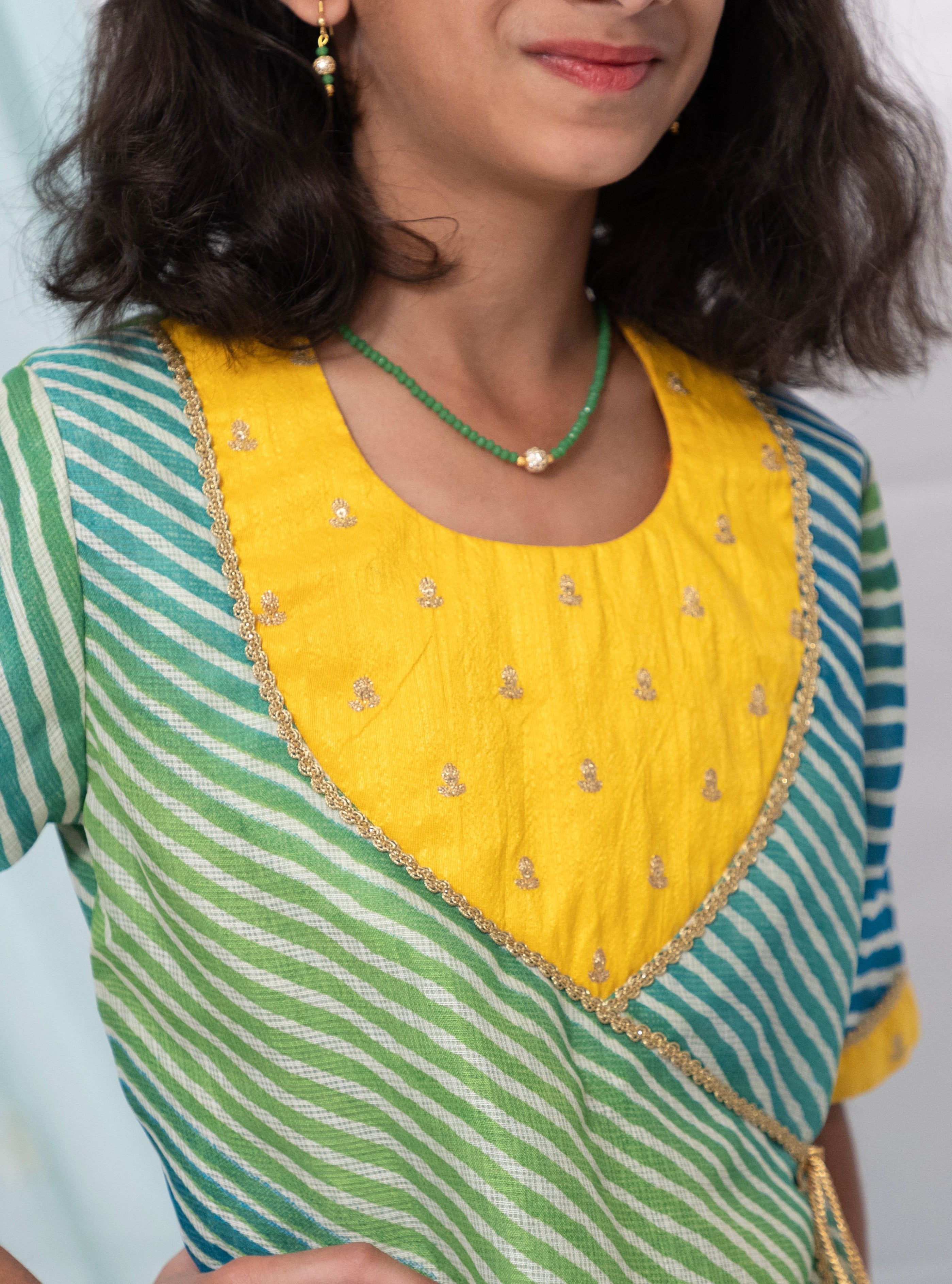 Blue and Green leheriya kotta chanderi kurti with yellow raw silk sequined yoke for Girls.Let your princess be as comfortable as in her casuals with carefully designed & crafted Comfort Ethnic Wear by Soyara Ethnics.Keep her fashion quotient high with timeless patterns, vibrant combinations and royal textiles.