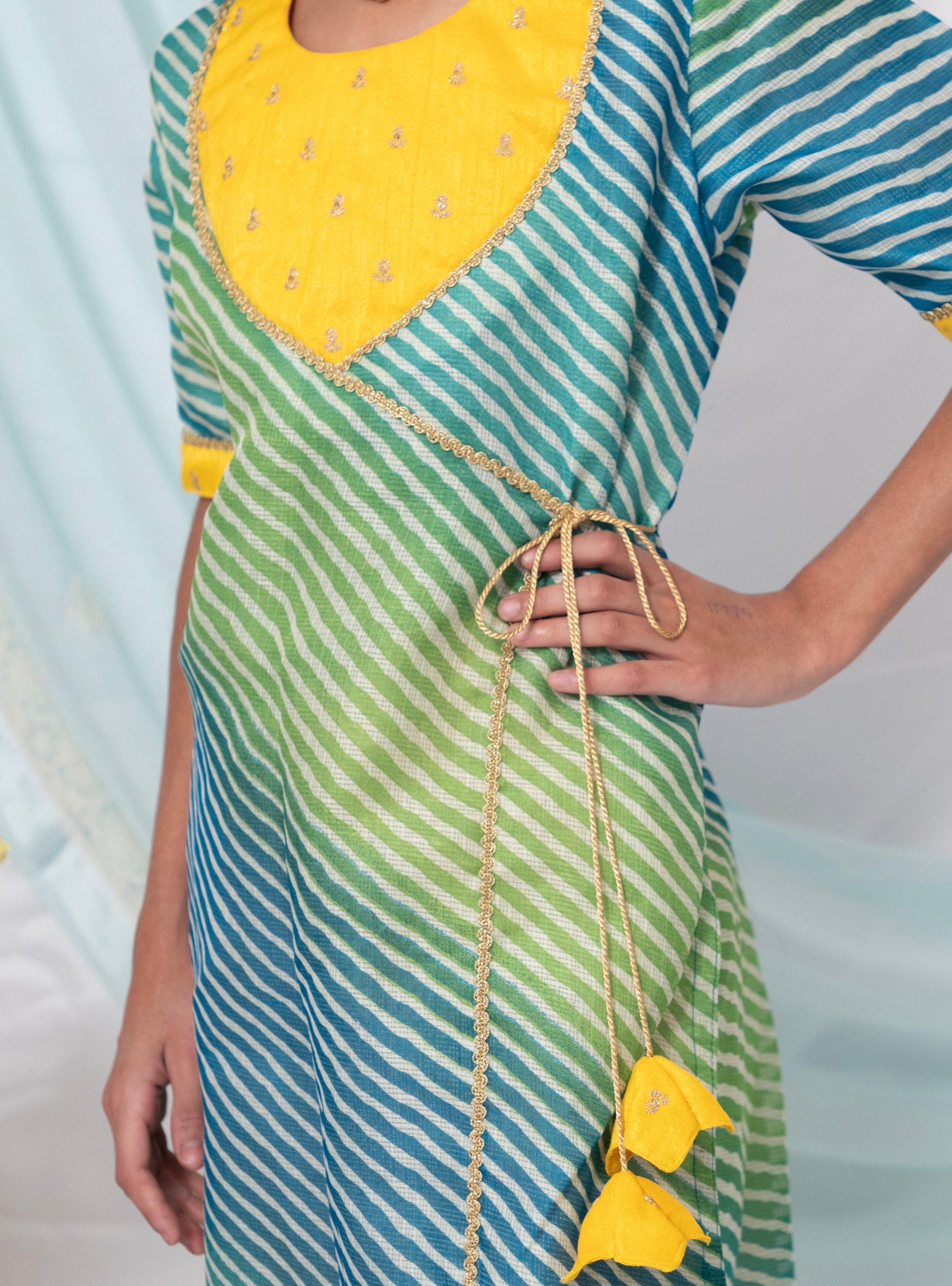 Blue and Green leheriya kotta chanderi kurti with yellow raw silk sequined yoke for Girls.Let your princess be as comfortable as in her casuals with carefully designed & crafted Comfort Ethnic Wear by Soyara Ethnics.Keep her fashion quotient high with timeless patterns, vibrant combinations and royal textiles.