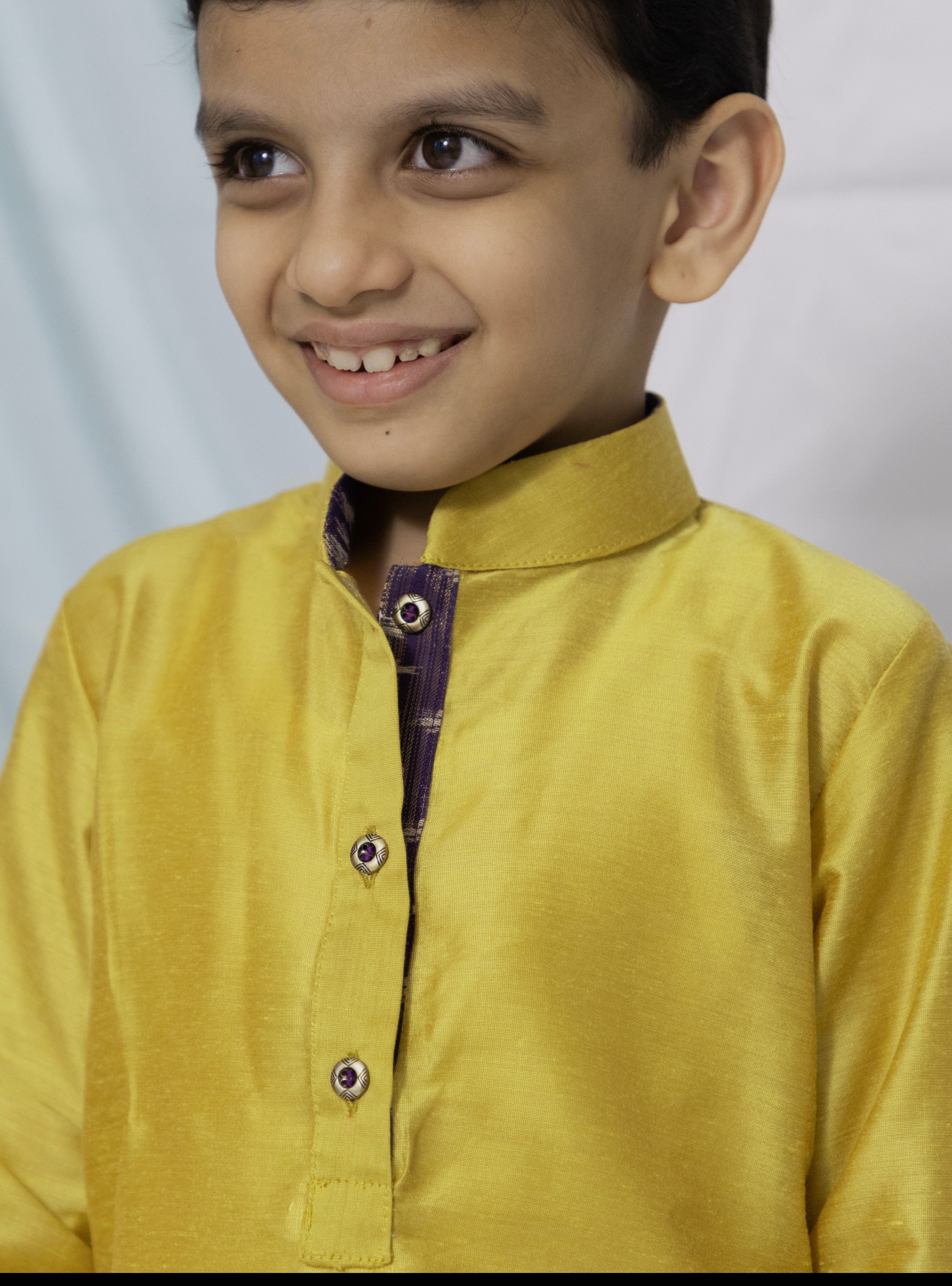 Enhance your traditional ensemble with this Olive yellow cotton silk kurta for Boys. Featuring a stand collar, orange placket detailing, and golden buttons, it can be paired with salwar or jeans for a stylish and comfortable look.