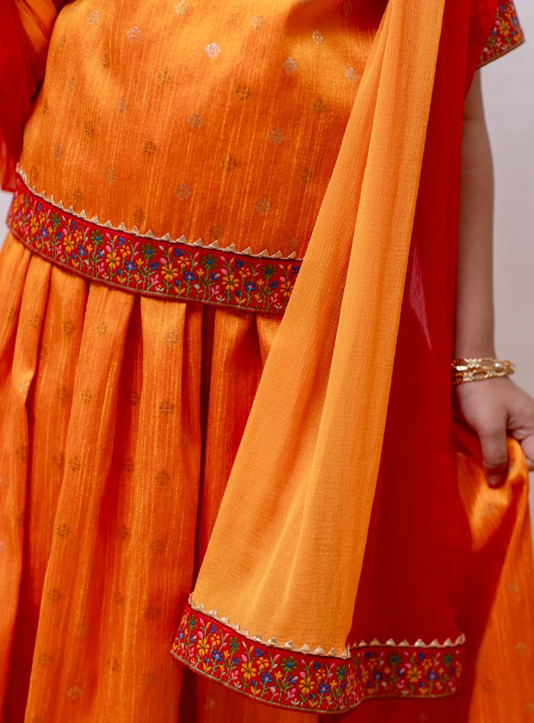 Turmeric Yellow Raw silk Ghagra choli with burning red fulkari embroidered border at the bottom and sleeves for Girls.Let your princess be as comfortable as in her casuals with carefully designed and crafted Comfort Ethnic Wear by Soyara Ethnics. Keep her fashion quotient high with timeless patterns, vibrant combinations and royal textiles.