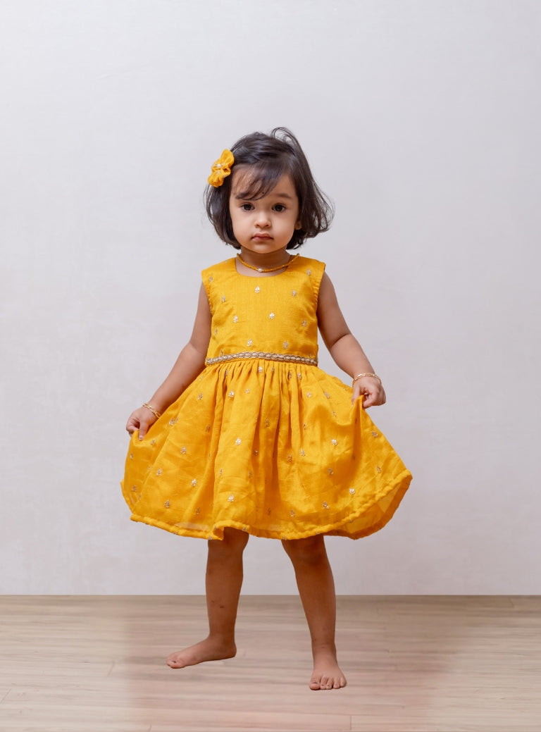 Royal Yellow Vichitra silk sleeveless dress for Girls.Let your princess be as comfortable as in her casuals with carefully designed and crafted Comfort Ethnic Wear by Soyara Ethnics. Keep her fashion quotient high with timeless patterns, vibrant combinations and royal textiles.