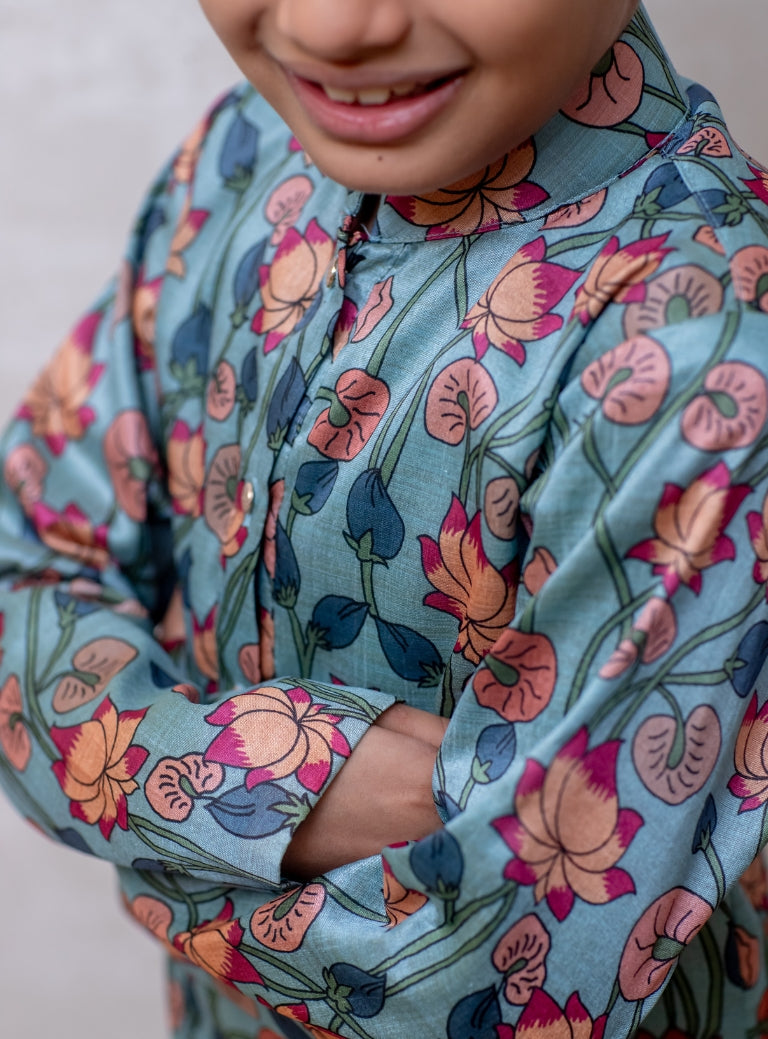 This Greish Sky blue tussar silk kurta features a lotus print and a stand collar accented with stone buttons. It is lined with cotton on the inside to provide enhanced comfort and superior quality.