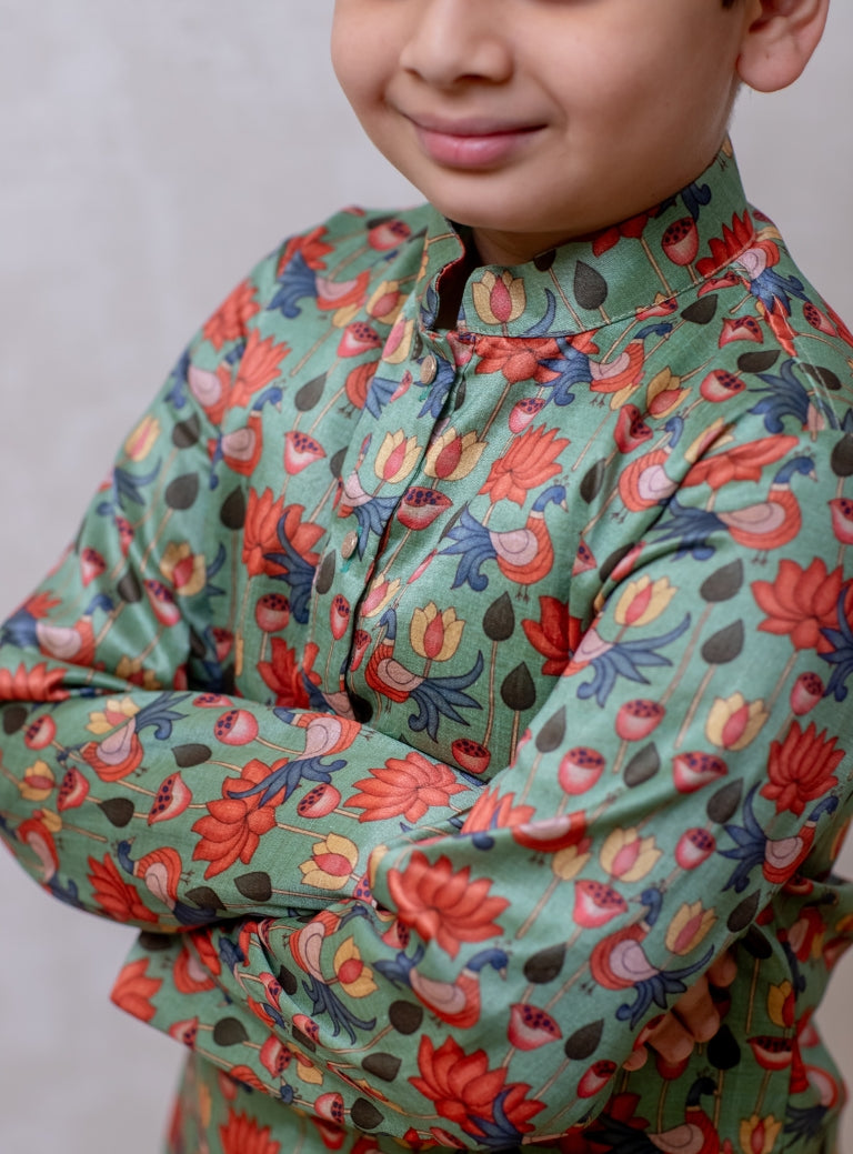 This Sage Green tussar silk kurta features a lotus print and a stand collar accented with stone buttons. It is lined with cotton on the inside to provide enhanced comfort and superior quality.