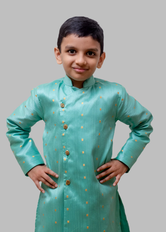 This boys' kurta features a pista mulberry silk fabric with a front open stand collar and distinctive stone-studded buttons. It is paired with a Golden Banglori silk salwar, and the kurta includes a comfortable cotton lining for added comfort.