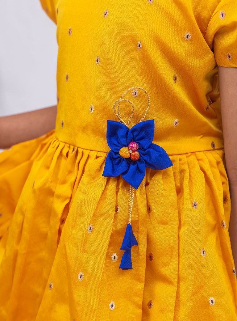 This stunning dress is made of yellow taffeta silk and features elegant puff sleeves. The dress also includes a delicate handmade fabric flower brooch, adding a touch of sophistication. A matching blue hair clip is included for a coordinated look.