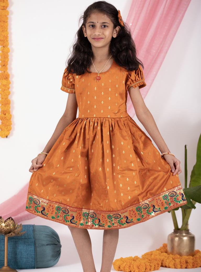 Rust colored taffeta silk frock with intricate peacock paithani border for Girls