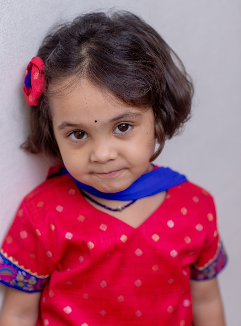 Tomato red Raw silk Ghagra choli with shocking blue fulkari embroidered border at the bottom and sleeves for Girls.Let your princess be as comfortable as in her casuals with carefully designed and crafted Comfort Ethnic Wear by Soyara Ethnics. Keep her fashion quotient high with timeless patterns, vibrant combinations and royal textiles.