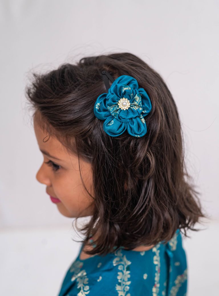 Peacock green banaras satin brocade silk gown with cap sleeves and ruffled flare for Girls.Let your princess be as comfortable as in her casuals with carefully designed & crafted Comfort Ethnic Wear by Soyara Ethnics.Keep her fashion quotient high with timeless patterns, vibrant combinations and royal textiles.