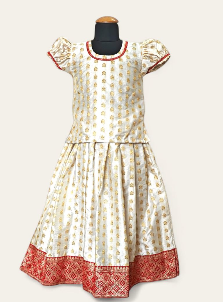 Featuring a white brocade satin silk parkar polka, with a heavy banarasi border and elegant lace accents around the neck and arms.