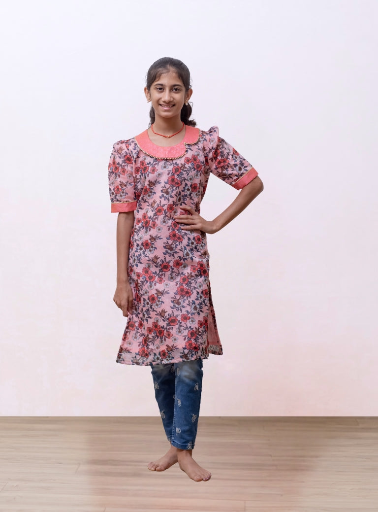 Peach floral printed Chanderi kurti with fancy peter pan collar and mutton sleeves with gotta patti highlight for Girls.Let your princess be as comfortable as in her casuals with carefully designed & crafted Comfort Ethnic Wear by Soyara Ethnics.Keep her fashion quotient high with timeless patterns, vibrant combinations and royal textiles.