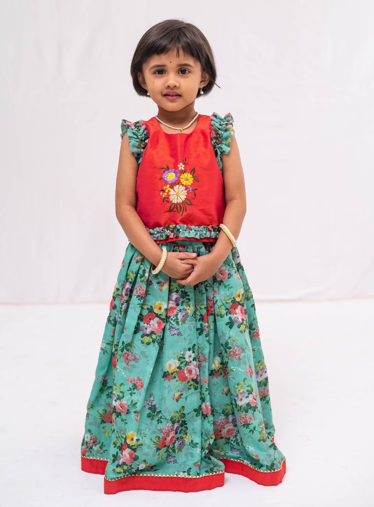 This Cyan coloured ghagra is flaunting floral prints and is crafted in chanderi. Featuring ruffled sleeves in raw silk embroidered orange choli, the sleeves are further highlighted with pearl embellishments. The orange border of the ghagra is adorned with gotta Patti embellishments.