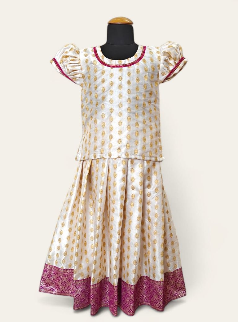 Featuring a white brocade satin silk parkar polka, with a heavy banarasi border and elegant lace accents around the neck and arms.