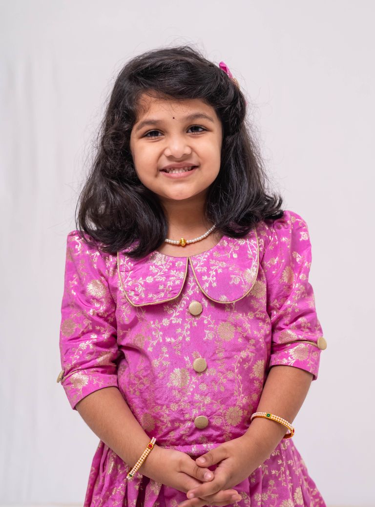 This Lilac banaras brocade ghagra is complemented by a Peterpan collared mutton sleeved choli.Let your princess be as comfortable as in her casuals with carefully designed & crafted Comfort Ethnic Wear by Soyara Ethnics.Keep her fashion quotient high with timeless patterns, vibrant combinations and royal textiles.