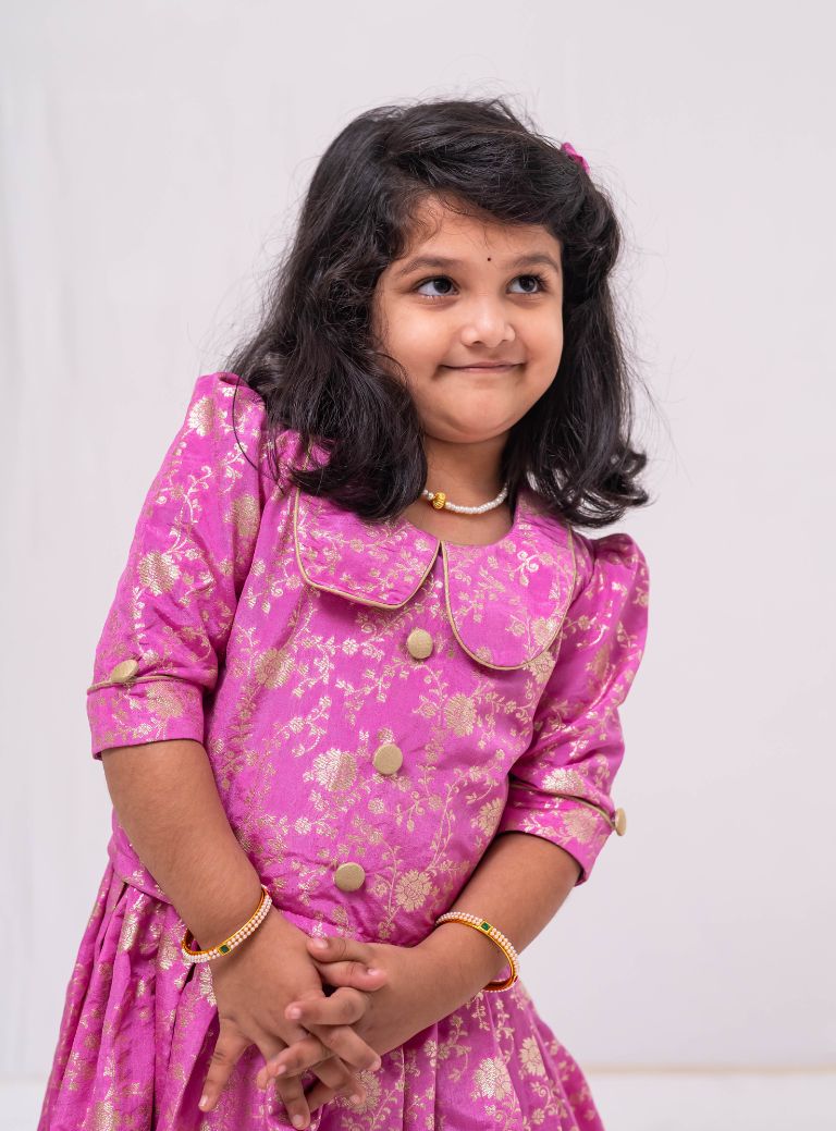 This Lilac banaras brocade ghagra is complemented by a Peterpan collared mutton sleeved choli.Let your princess be as comfortable as in her casuals with carefully designed & crafted Comfort Ethnic Wear by Soyara Ethnics.Keep her fashion quotient high with timeless patterns, vibrant combinations and royal textiles.