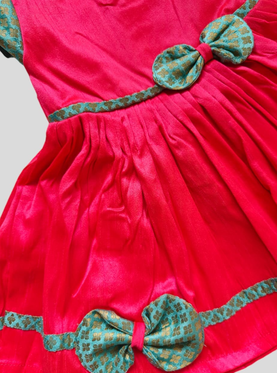 Candy Pink Raw silk dress with sky blue brocade sleeves and bow highlights for Girls.Let your princess be as comfortable as in her casuals with carefully designed & crafted Comfort Ethnic Wear by Soyara Ethnics.Keep her fashion quotient high with timeless patterns, vibrant combinations and royal textiles.