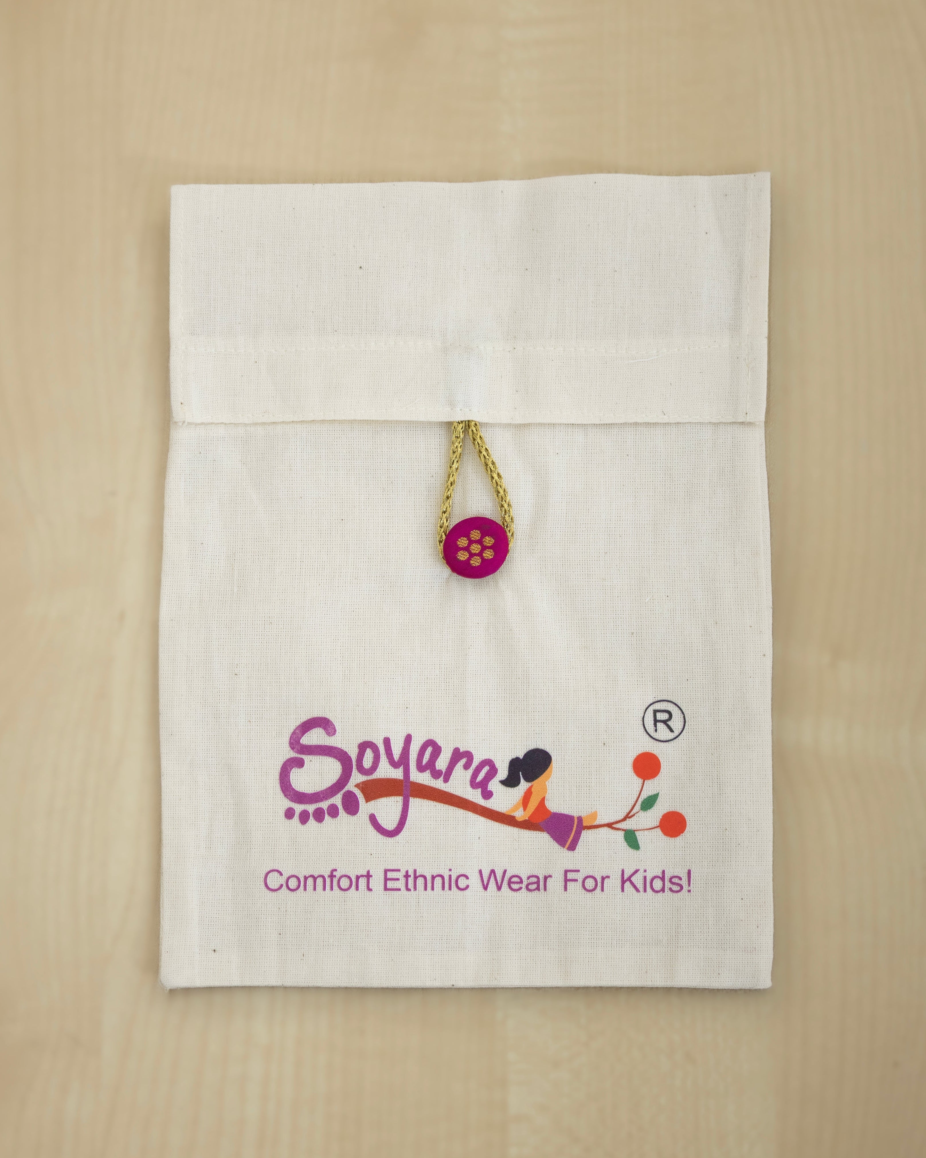White muslin pouch with 'Soyara' logo and statement fabric button , perfect for gift wrapping accessories .