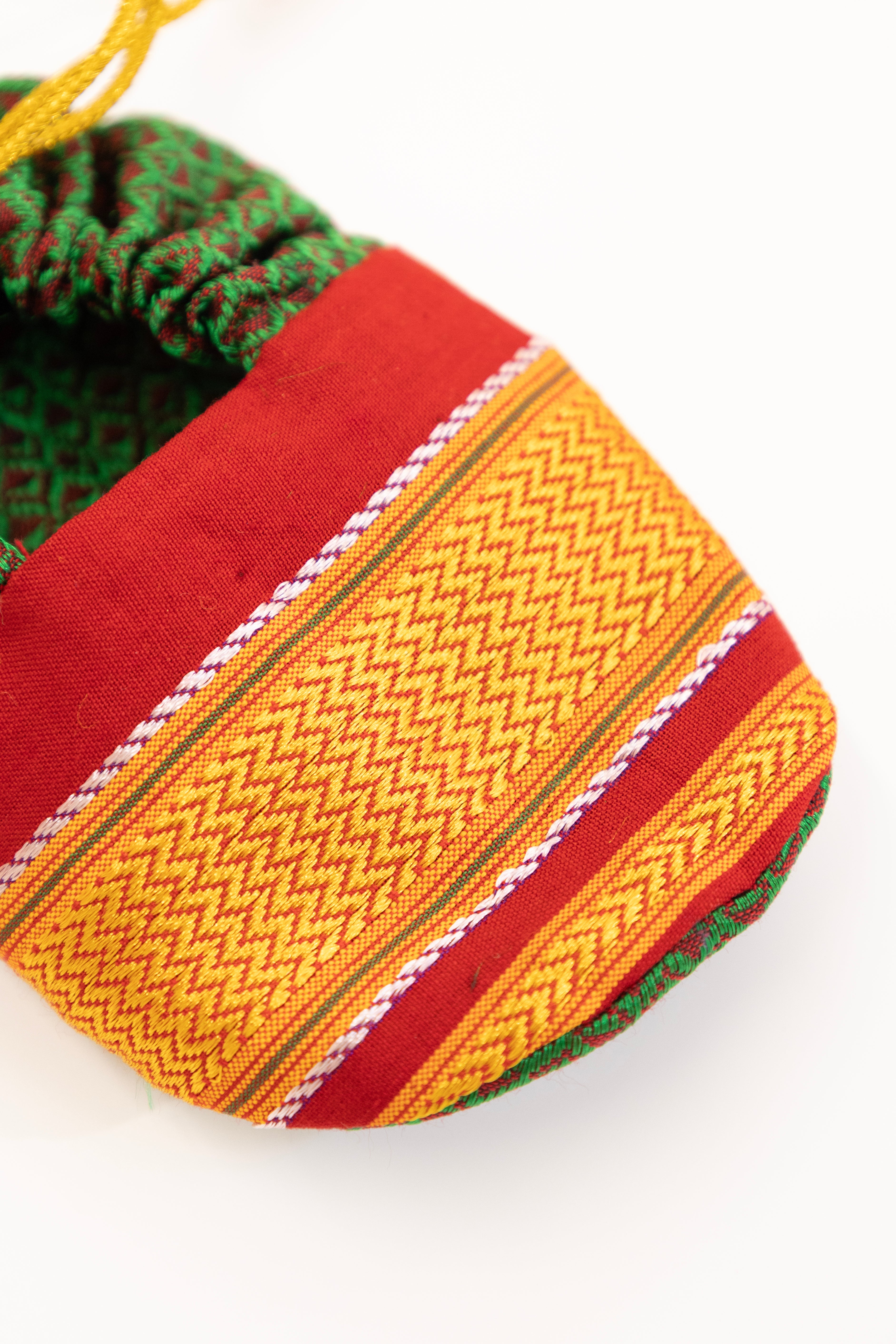 Green handloom khunn with red border topda / topi/ bonnet with coordinated khunn booties set for NewBorn. Handcrafted accessories for Newborn are perfect add ons to any traditional attire of the baby.Designer baby mats,set of generic bloomers are other naming ceremony essentials.