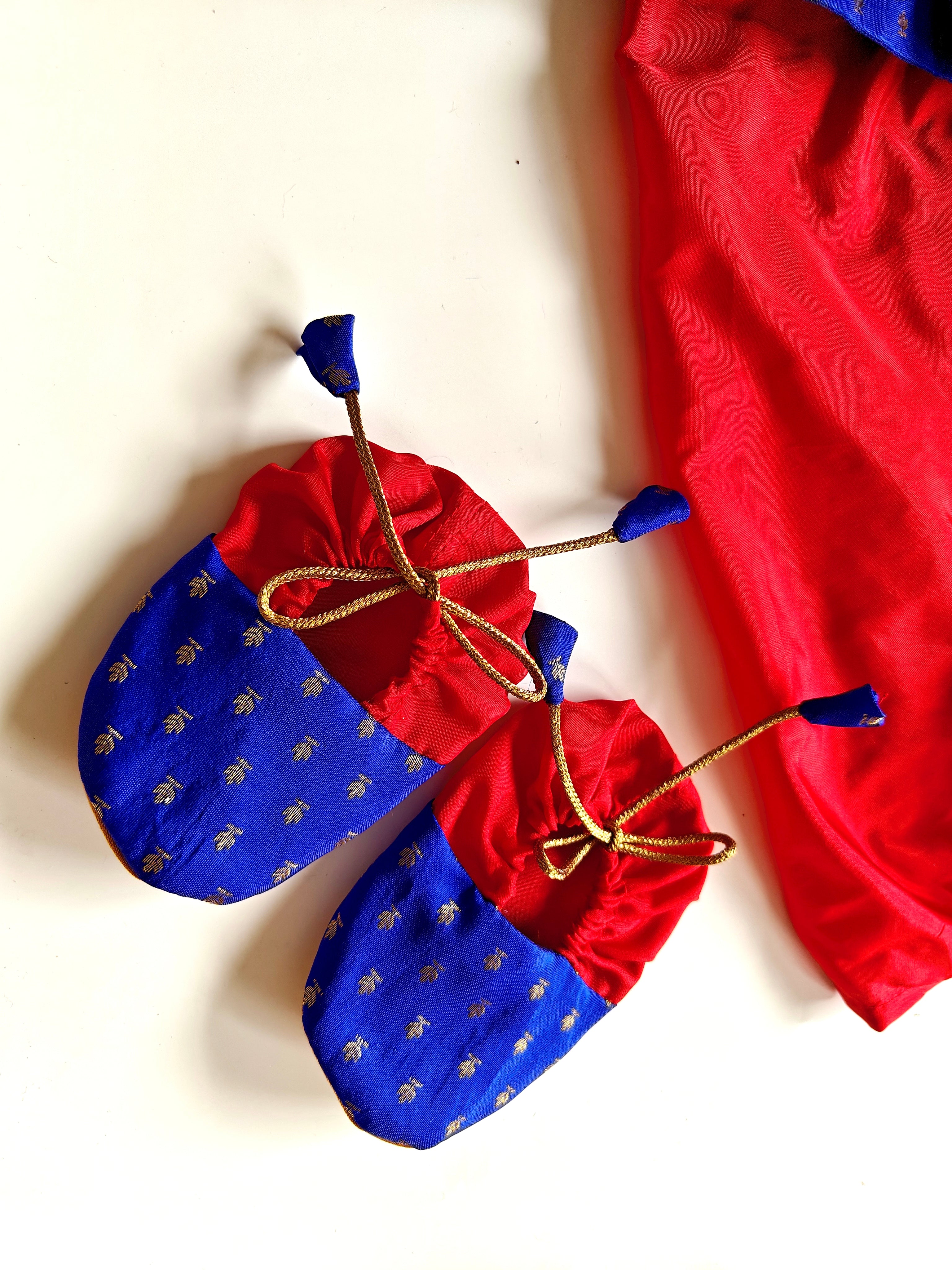 This Sharad Kurta and dhoti ensemble for baby boys features a soft brocade silk front-open kurta adorned with contrasting lace details, paired with a vibrant aqua green pooja silk dhoti. The set is completed with a matching bonnet and booties, offering a coordinated and elegant traditional outfit.