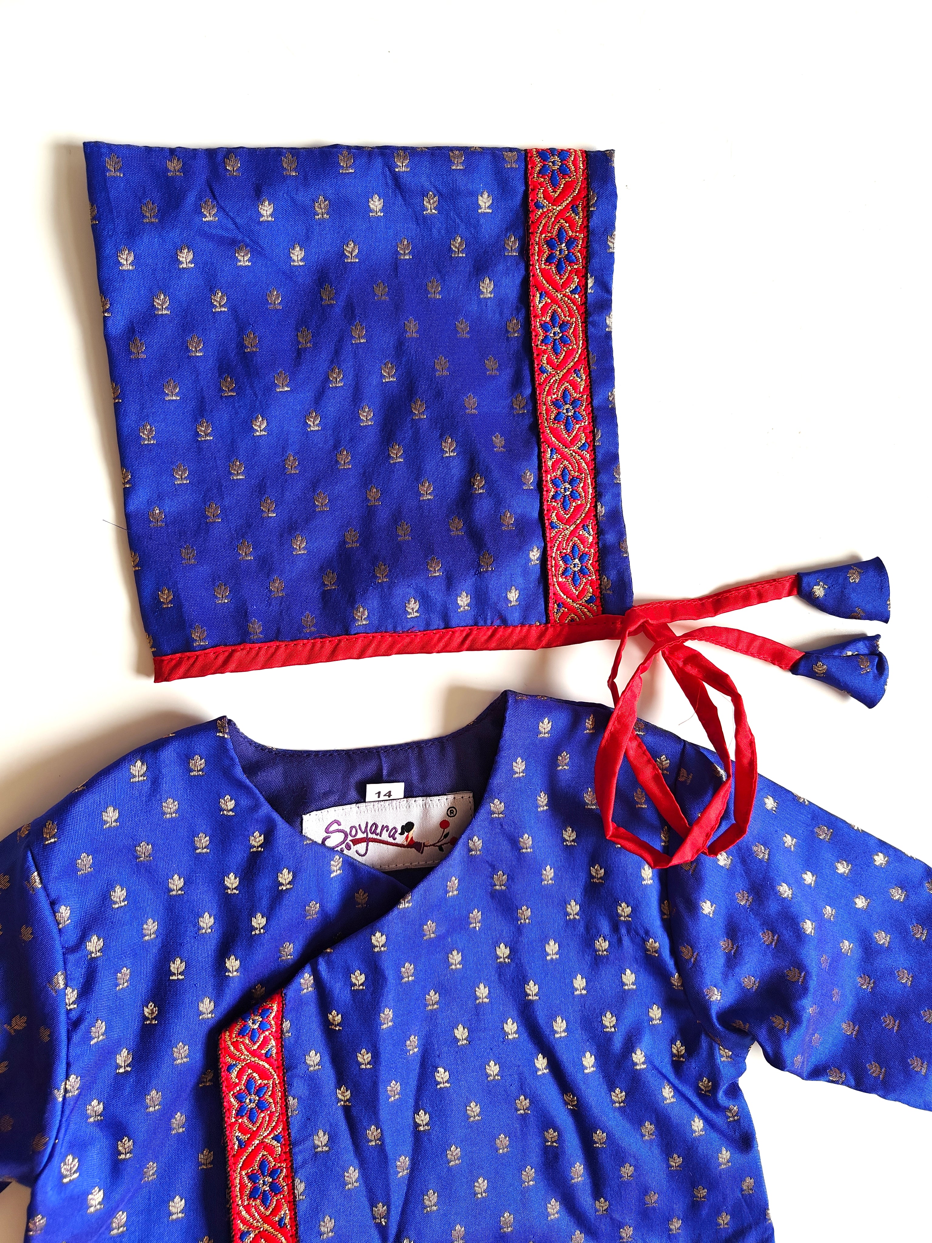 This Sharad Kurta and dhoti ensemble for baby boys features a soft brocade silk front-open kurta adorned with contrasting lace details, paired with a vibrant aqua green pooja silk dhoti. The set is completed with a matching bonnet and booties, offering a coordinated and elegant traditional outfit.