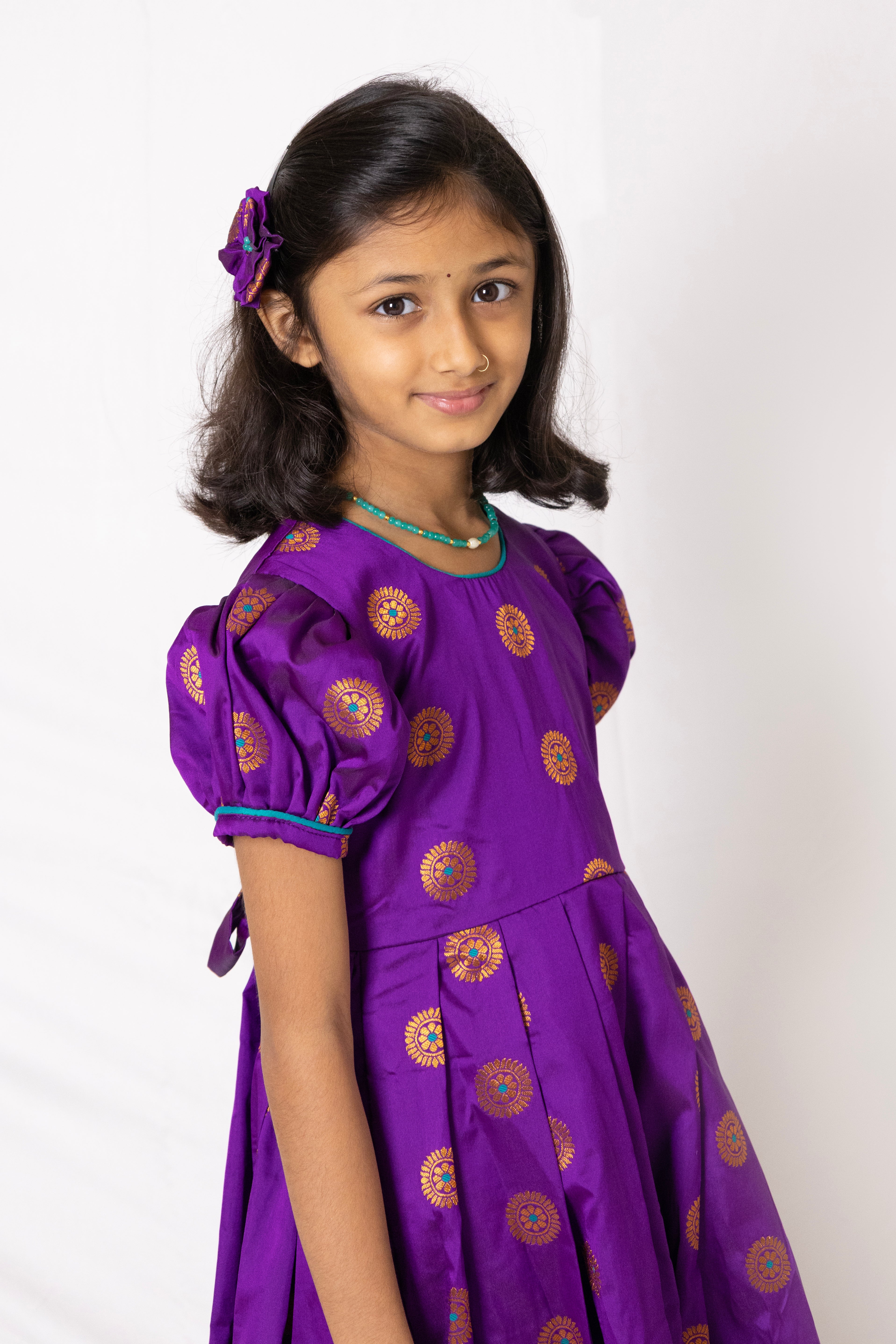 Purple jacquard brocade silk midi dress with broad paithani border for Girls.Let your princess be as comfortable as in her casuals with carefully designed and crafted Comfort Ethnic Wear by Soyara Ethnics. Keep her fashion quotient high with timeless patterns, vibrant combinations and royal textiles.