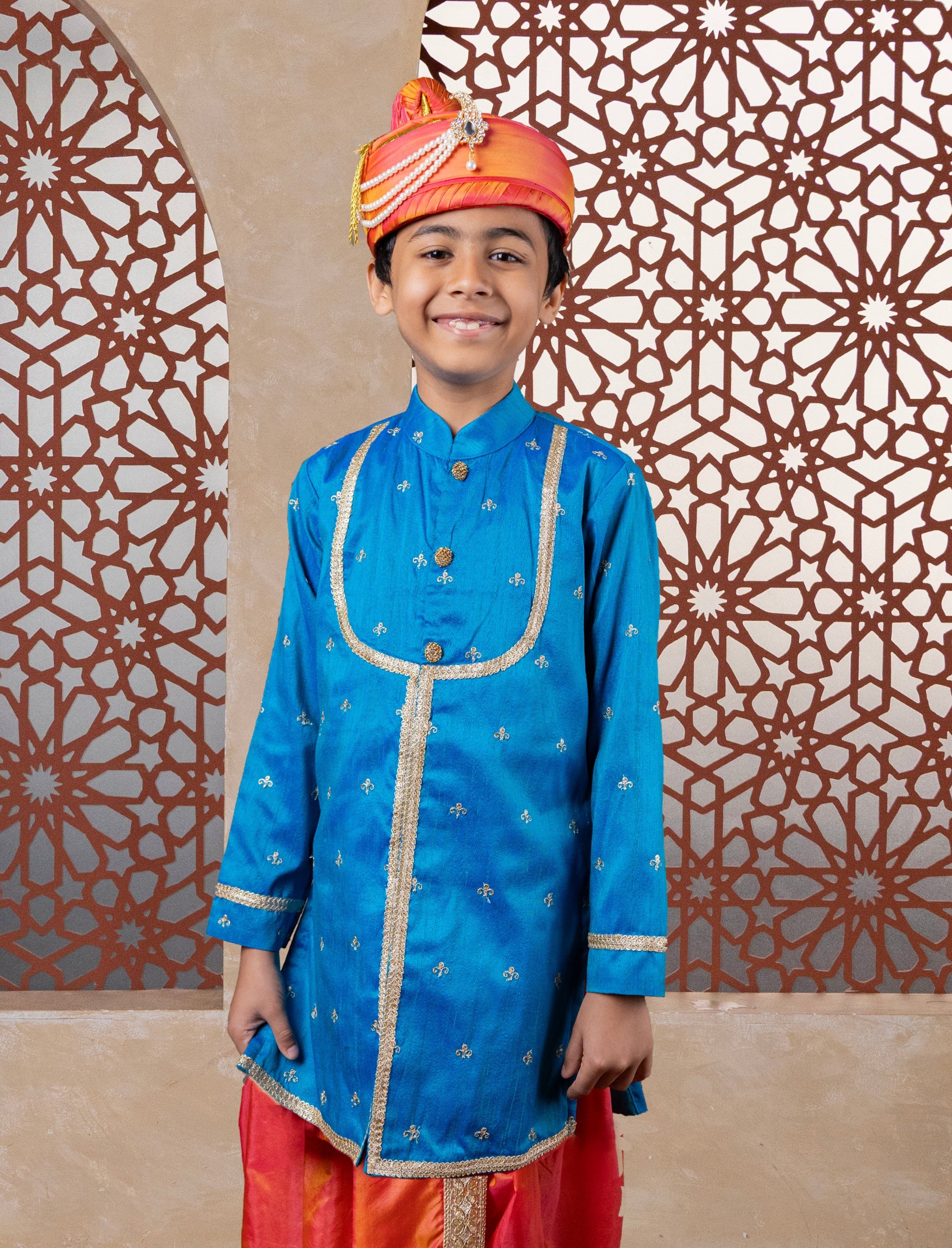 This teal blue raw silk kurta features a detailed yoke design highlighted by intricate all-over zari embroidery. It is elegantly finished with stone-studded buttons for a refined touch.