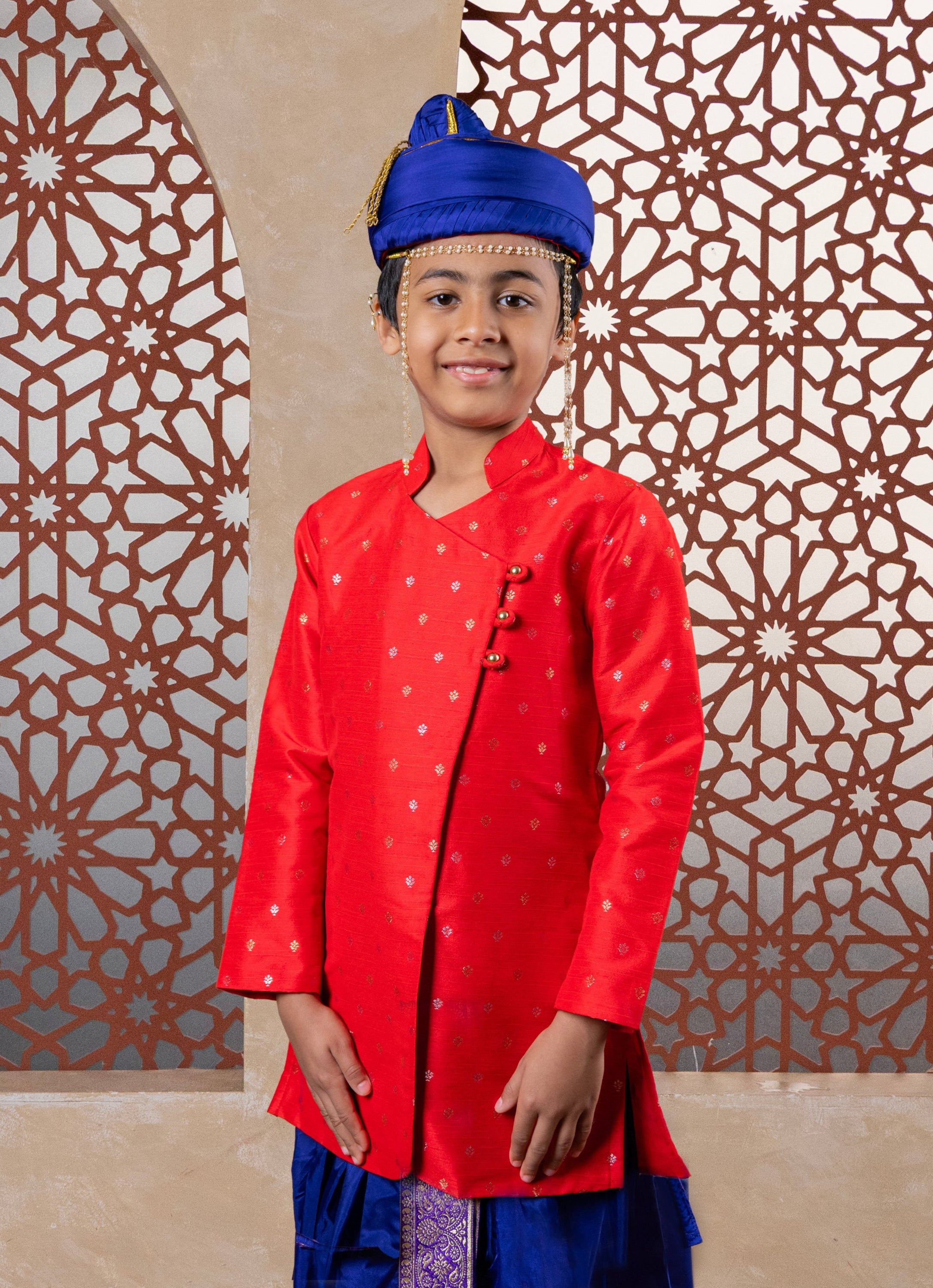 This Bright Red kurta features a half stand collar and is crafted from raw silk adorned with zari motifs. It showcases an elegant overlap pattern, perfect for Batu occasions.
