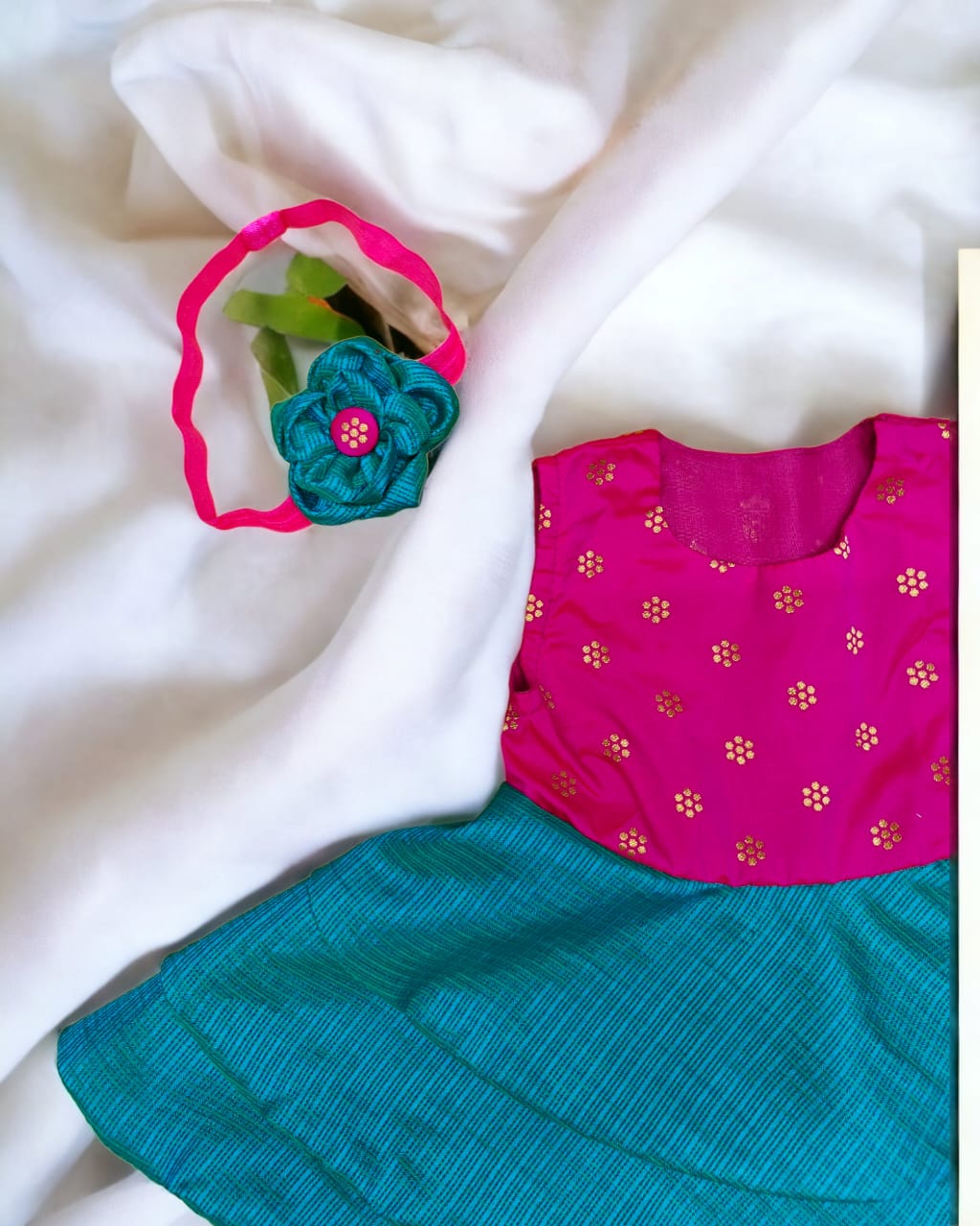 Rani pink with peacock green front open layered dress with coordinated bloomer , headband and booties for a newborn baby girl.
