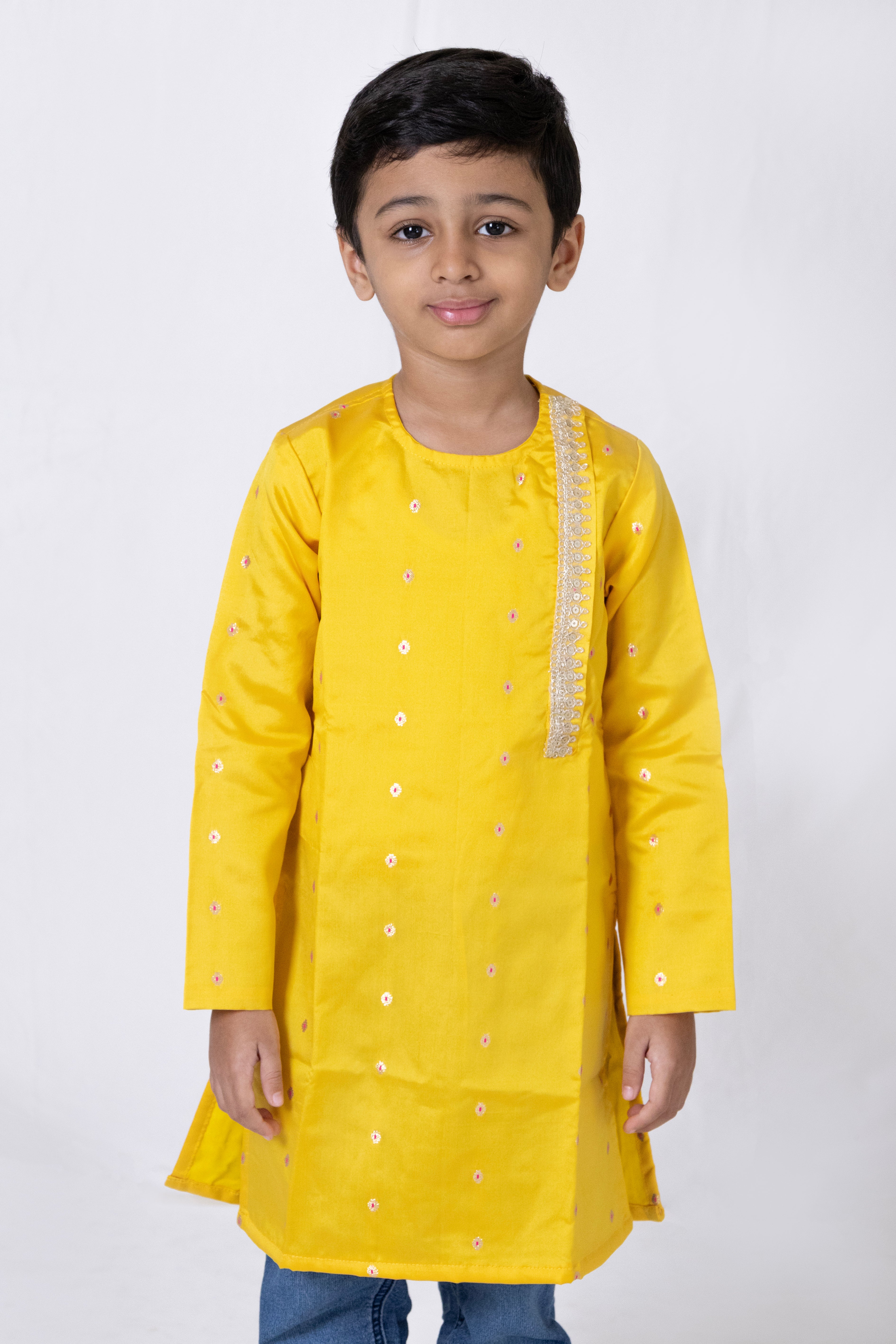 This yellow taffeta silk kurta for boys features a side placket adorned with sequined lace detailing. The garment is lined with cotton for enhanced comfort and superior quality.
