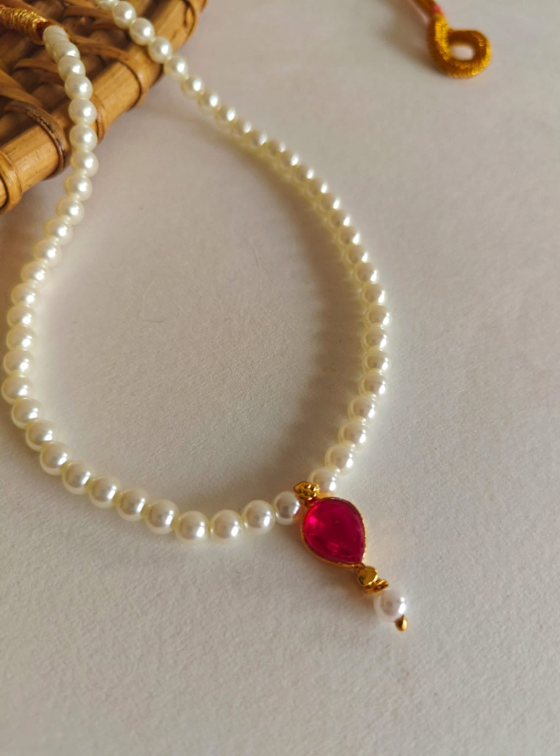 This necklace features semi-cultured pearls and a Karwari Drop shaped Pink Stone Pendant, perfect for girls. The length is 13 inches with an adjustable drawstring for added convenience.