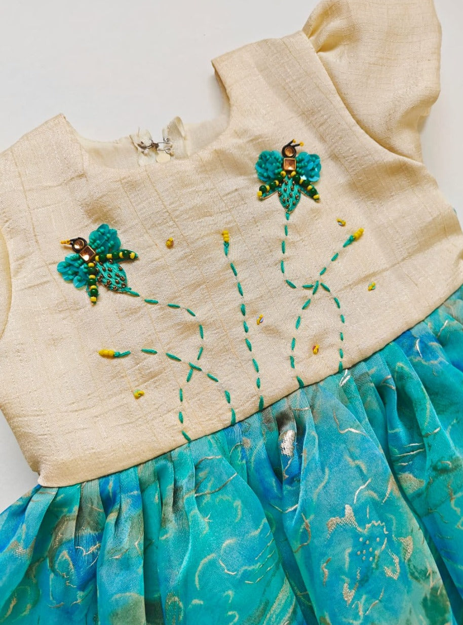 Nyasa silk bodice with foil printed organza bottom dress with handwork, beaded fly motifs for Girl.Let your princess be as comfortable as in her casuals with carefully designed & crafted Comfort Ethnic Wear by Soyara Ethnics.Keep her fashion quotient high with timeless patterns, vibrant combinations and royal textiles.