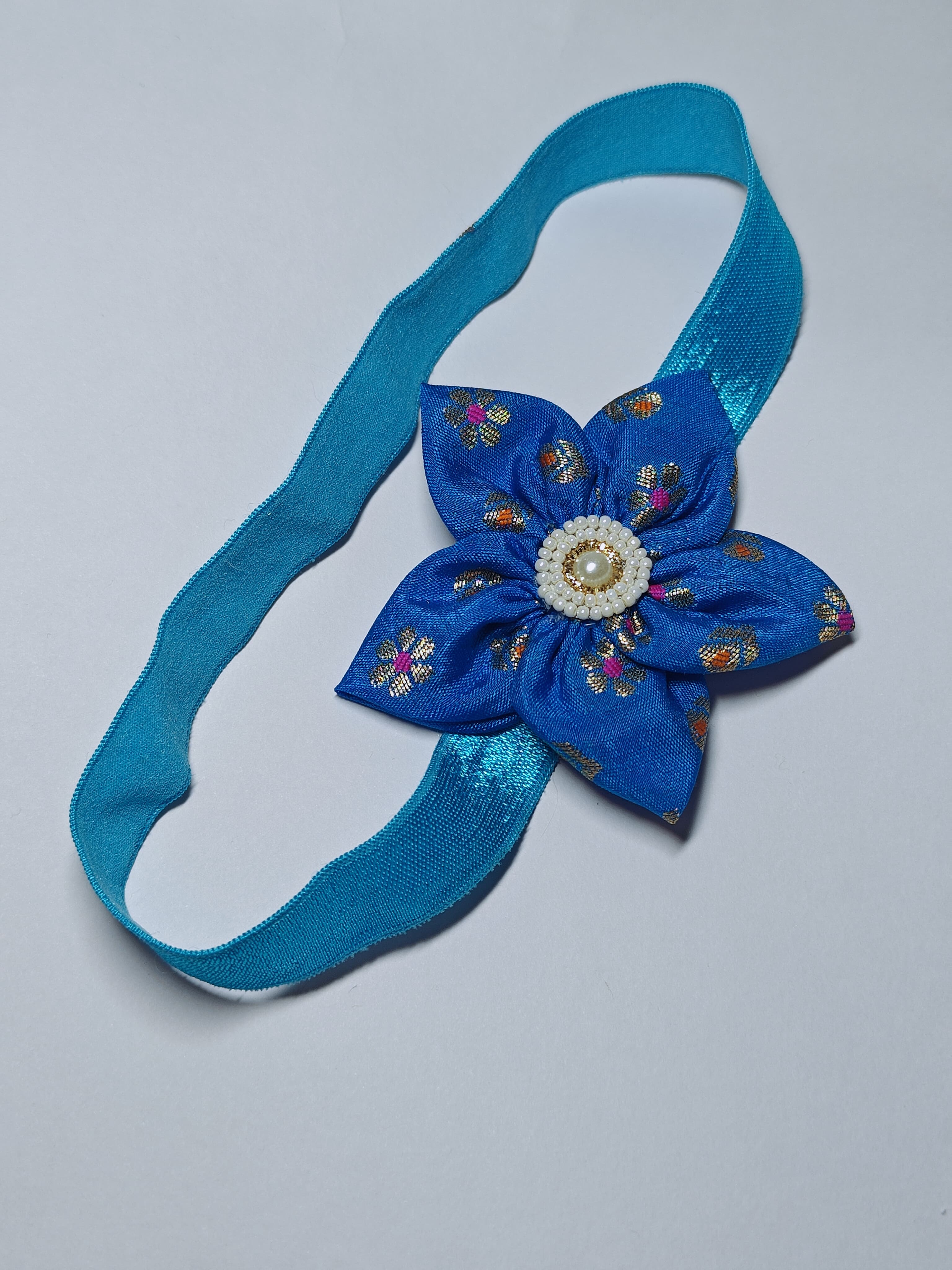 Cool Coloured Sadafuli Flower Stretchable headband for baby girl.Adorn your princess with head to toe premium quality handcrafted accessories made from allergy free, best quality materials.