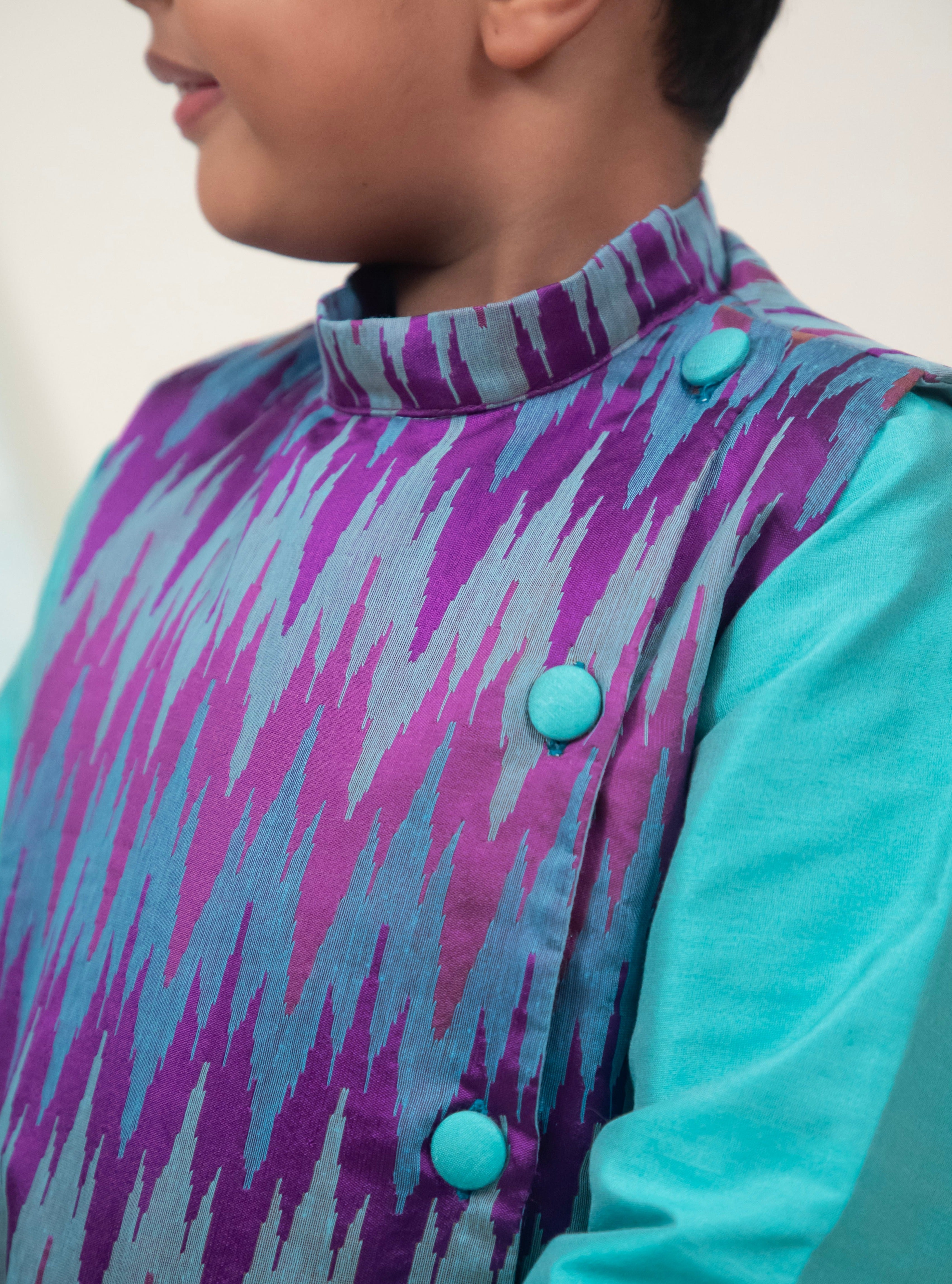 Cyan coloured cotton silk salwar kurta set with embossed patola jacket for Boys.Kurtas with collar or Angrakha pattern teamed with salwar are the best choice for any festive occasion for boys. They are Trendy, Easy to wear and comfortable to carry.