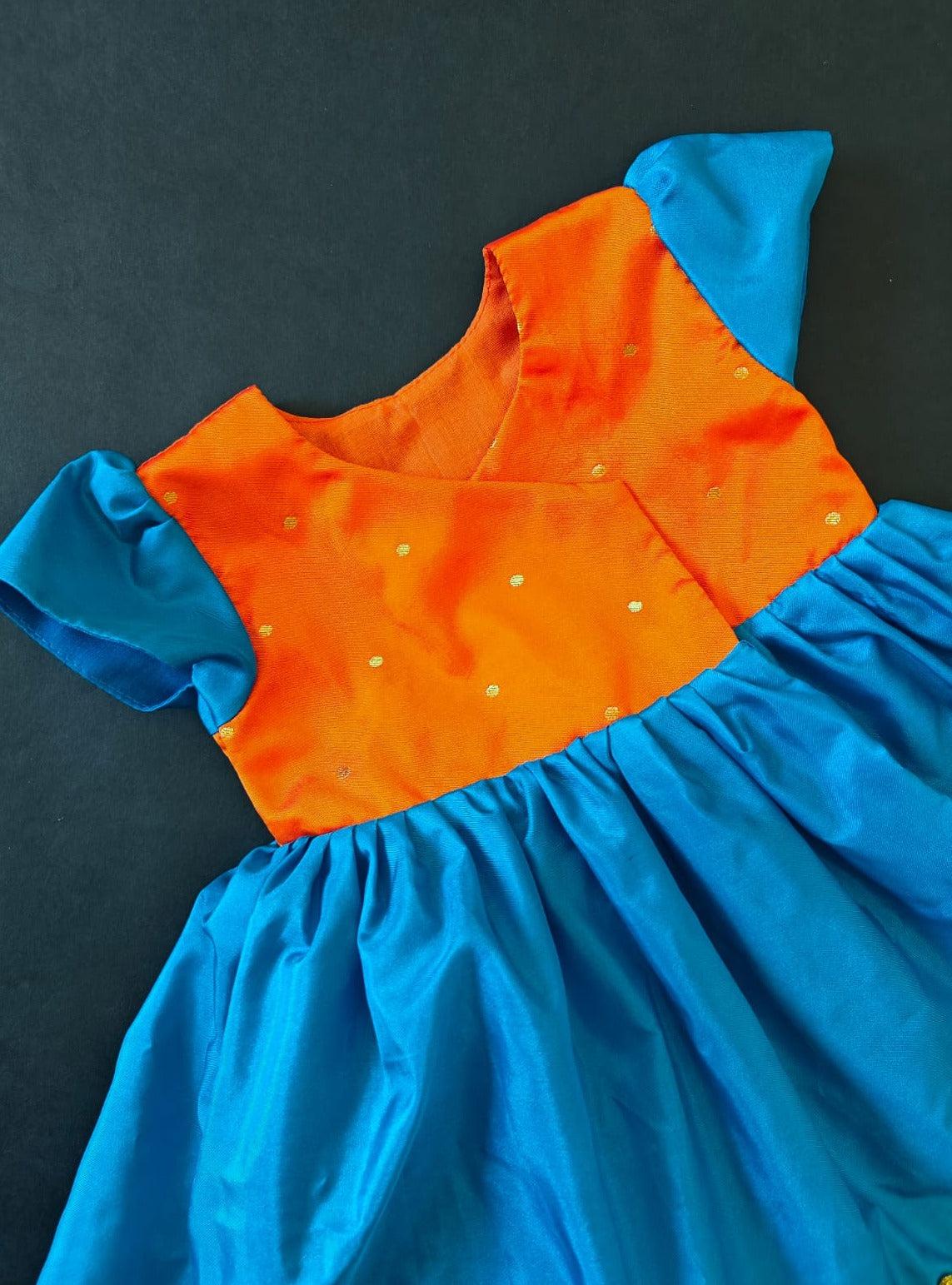 Orange brocade & teal blue silk front open dress for new born Baby Girl provides max comfort. It's the perfect outfit for your baby's naming ceremony , naamkaran or annaprashan ceremony. Traditional and ethnic dress for Noolukettu Ceremony, Paachvi Puja, Cradle ceremony,Rice Ceremony,Chatti Puja etc. Apt gifting idea.
