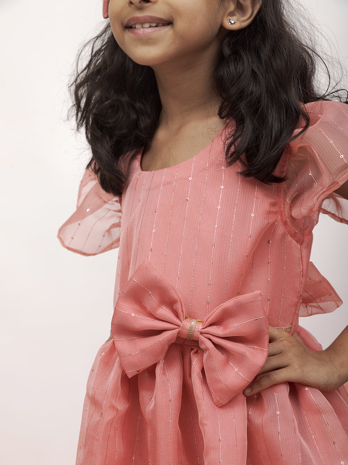Peach Sequined Kotta Organza Flared Dress With a dainty lace and a statement Bow at waist for Girl.Let your princess be as comfortable as in her casuals with carefully designed & crafted Comfort Ethnic Wear by Soyara Ethnics.Keep her fashion quotient high with timeless patterns, vibrant combinations and royal textiles.