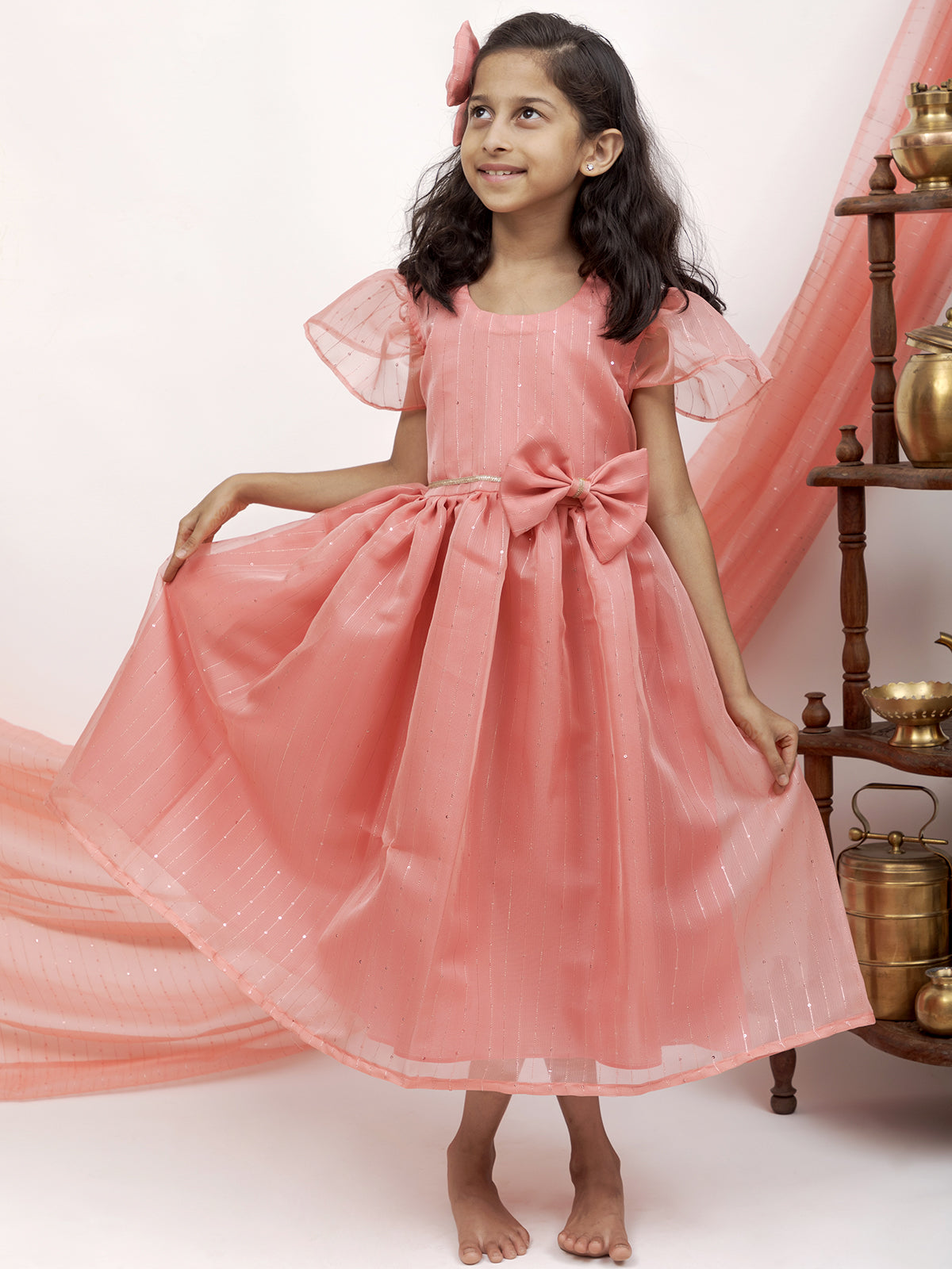 Peach Sequined Kotta Organza Flared Dress With a dainty lace and a statement Bow at waist for Girl.Let your princess be as comfortable as in her casuals with carefully designed & crafted Comfort Ethnic Wear by Soyara Ethnics.Keep her fashion quotient high with timeless patterns, vibrant combinations and royal textiles.