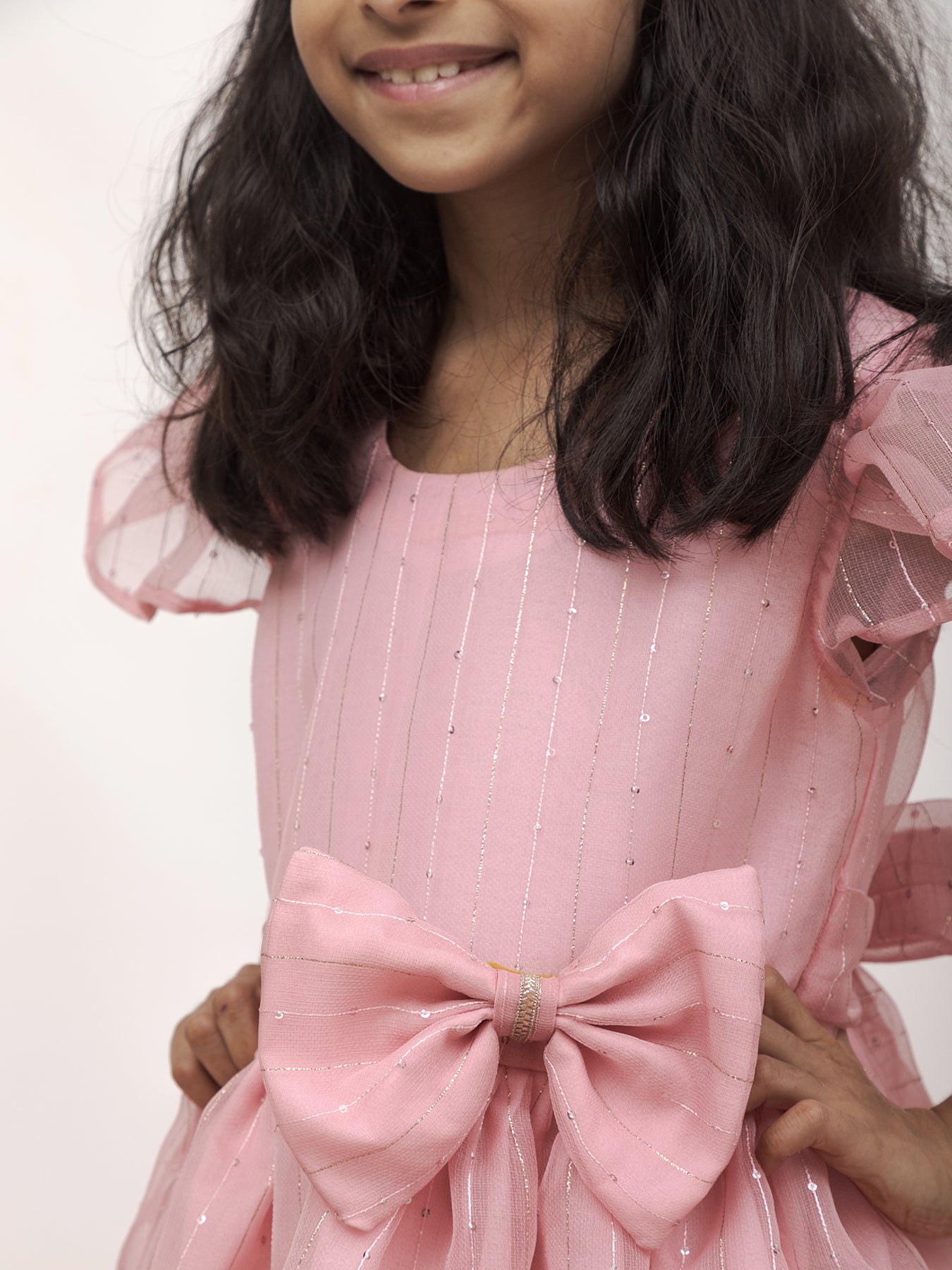 Baby Pink Sequined Kotta Organza Dress With a dainty lace & a statement Bow at waist for Girl.Let your princess be as comfortable as in her casuals with carefully designed & crafted Comfort Ethnic Wear by Soyara Ethnics.Keep her fashion quotient high with timeless patterns,vibrant combinations and royal textiles.