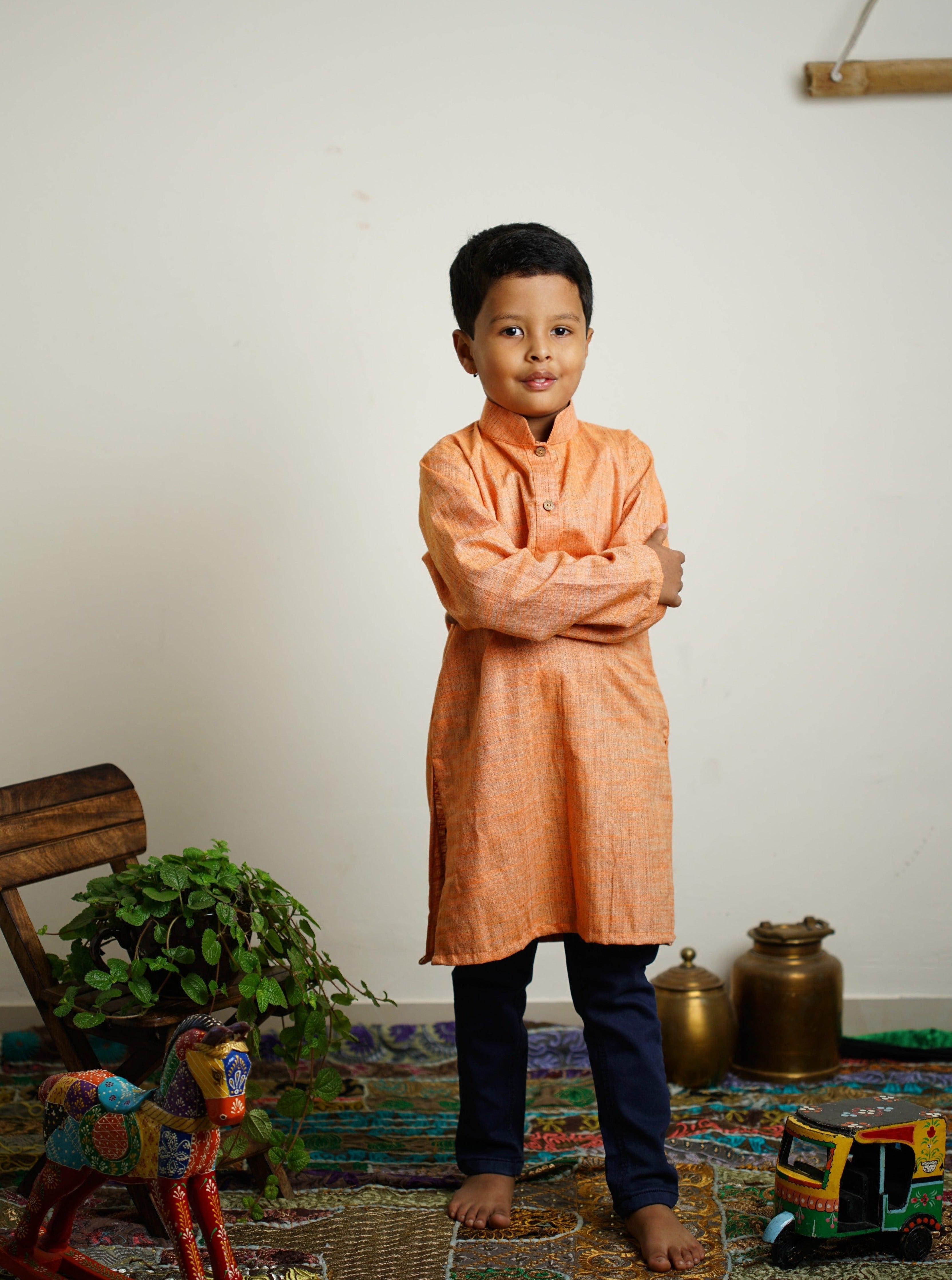 Light Orange Khadi silk stand collar long kurta with wooden buttons.Kurtas with collar or Angrakha pattern teamed with salwar are the best choice for any festive occasion for boys.They are Trendy, Easy to wear and comfortable to carry.