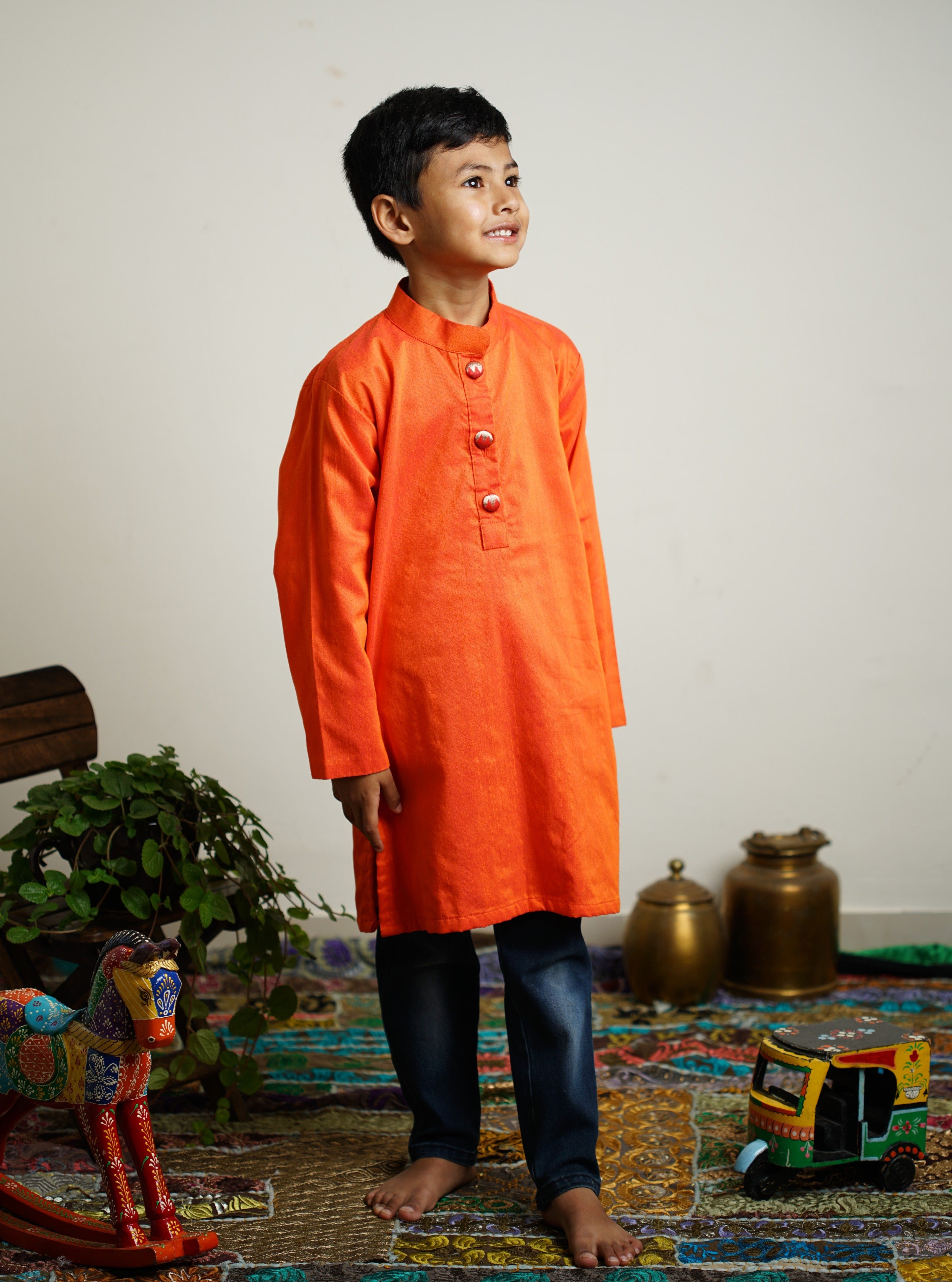 Orange cotton silk kurta with paithani fabric buttons.Kurtas with collar or Angrakha pattern teamed with salwar are the best choice for any festive occasion for boys.They are Trendy, Easy to wear and comfortable to carry.