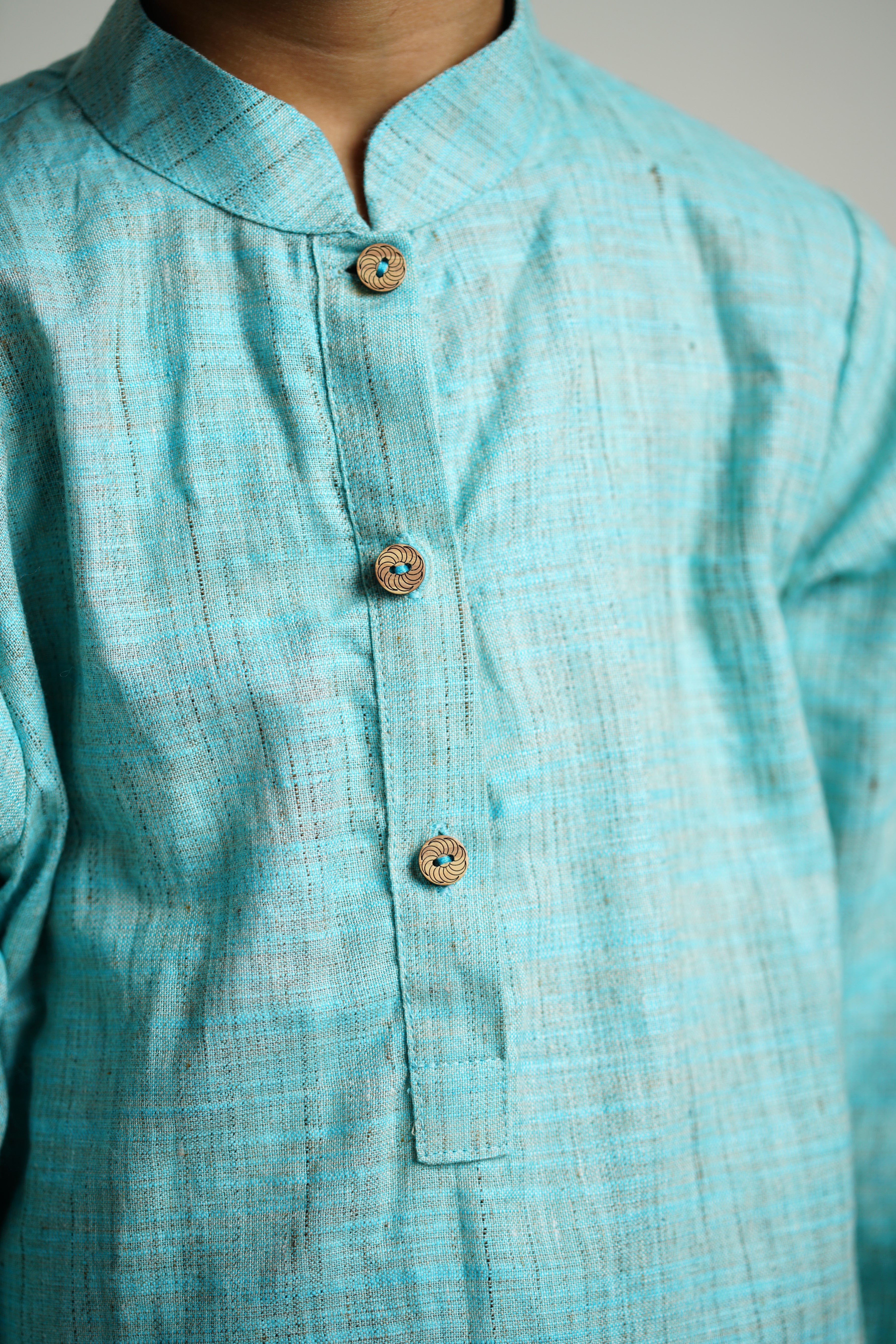 Sky Blue Khadi silk stand collar long kurta with wooden buttons.Kurtas with collar or Angrakha pattern teamed with salwar are the best choice for any festive occasion for boys.They are Trendy, Easy to wear and comfortable to carry.