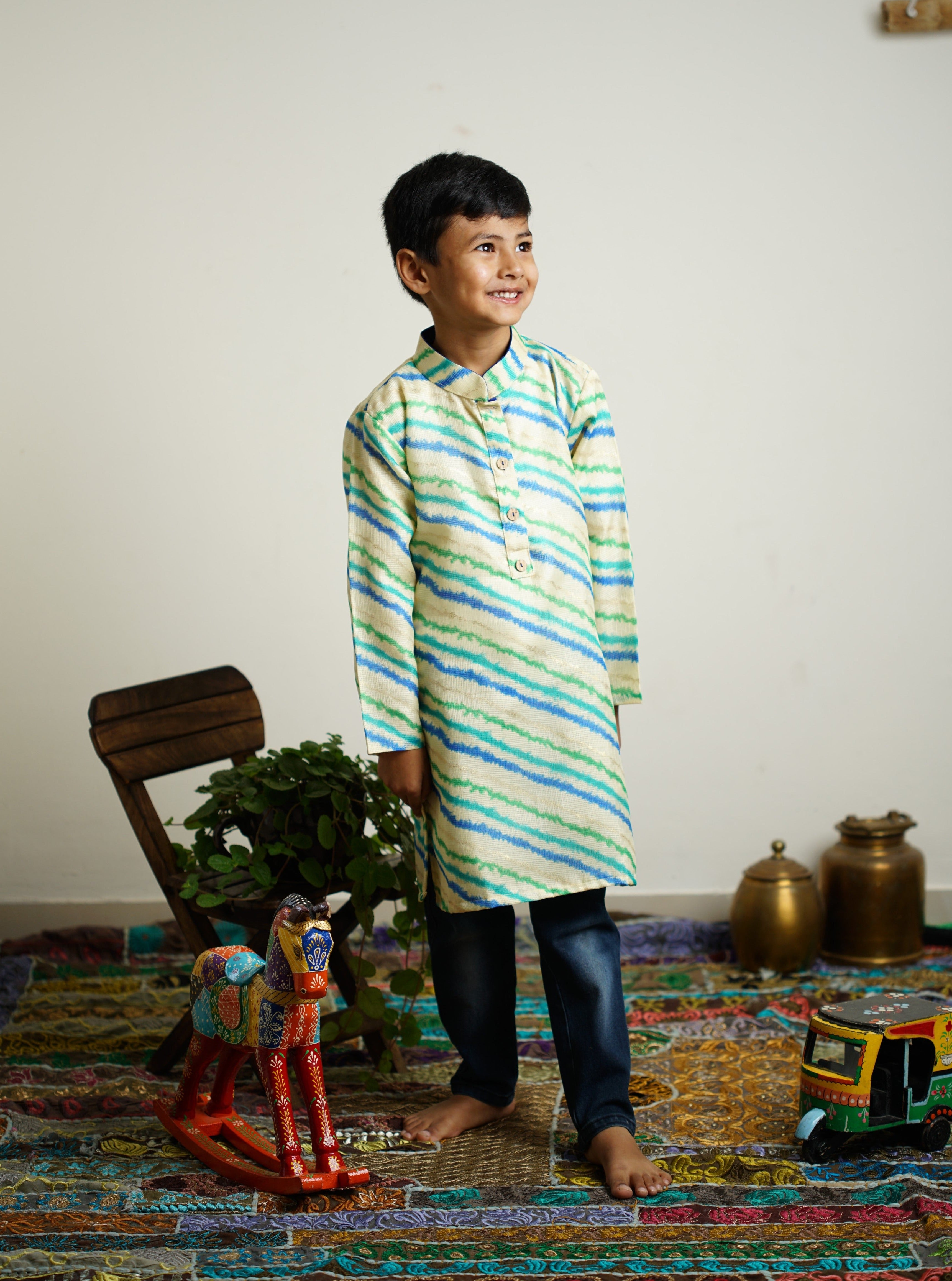 Off white leheriya kotta fabric stand collar long kurta with wooden buttons.Kurtas with collar or Angrakha pattern teamed with salwar are the best choice for any festive occasion for boys.They are Trendy, Easy to wear and comfortable to carry.