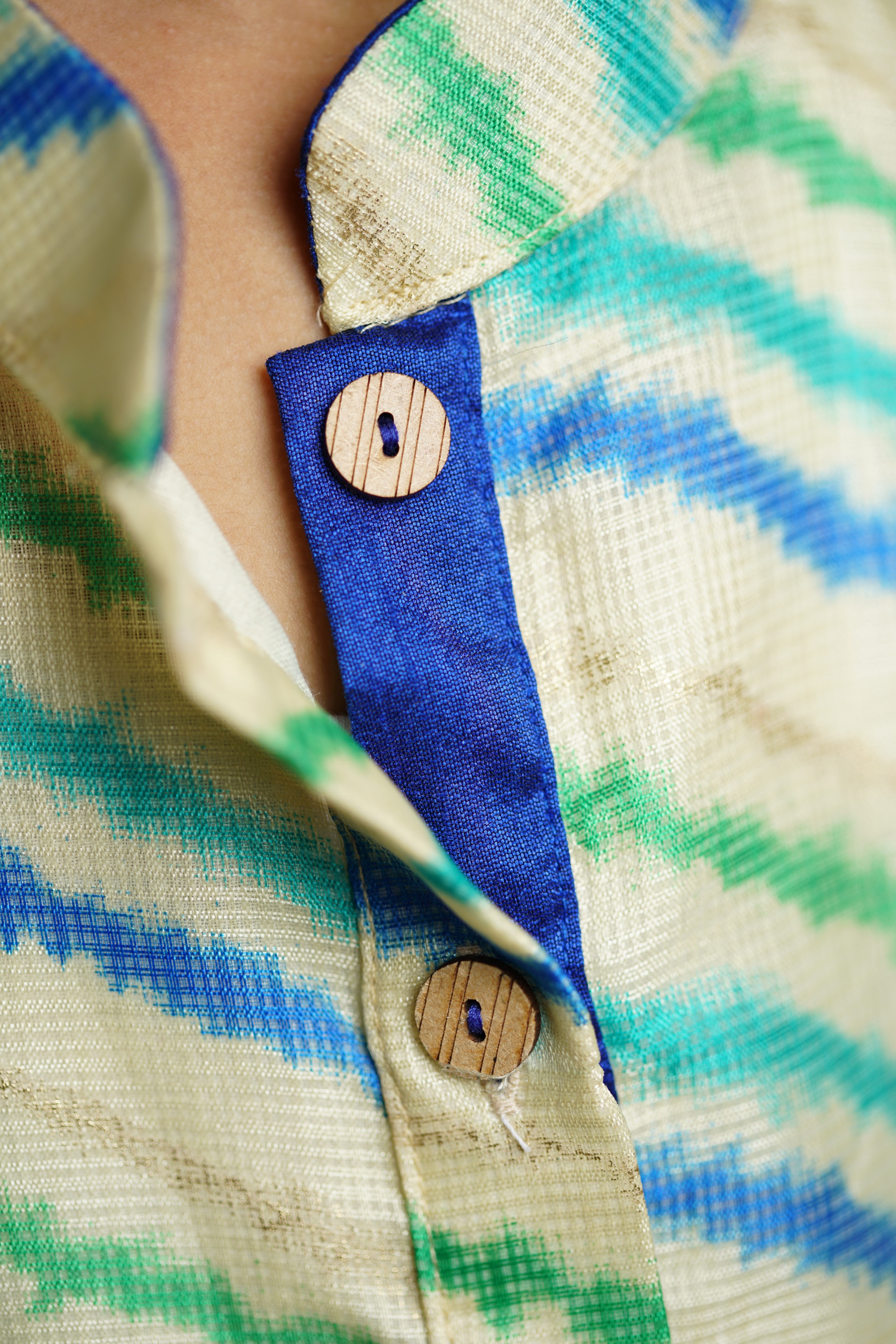 Off white leheriya kotta fabric stand collar long kurta with wooden buttons.Kurtas with collar or Angrakha pattern teamed with salwar are the best choice for any festive occasion for boys.They are Trendy, Easy to wear and comfortable to carry.