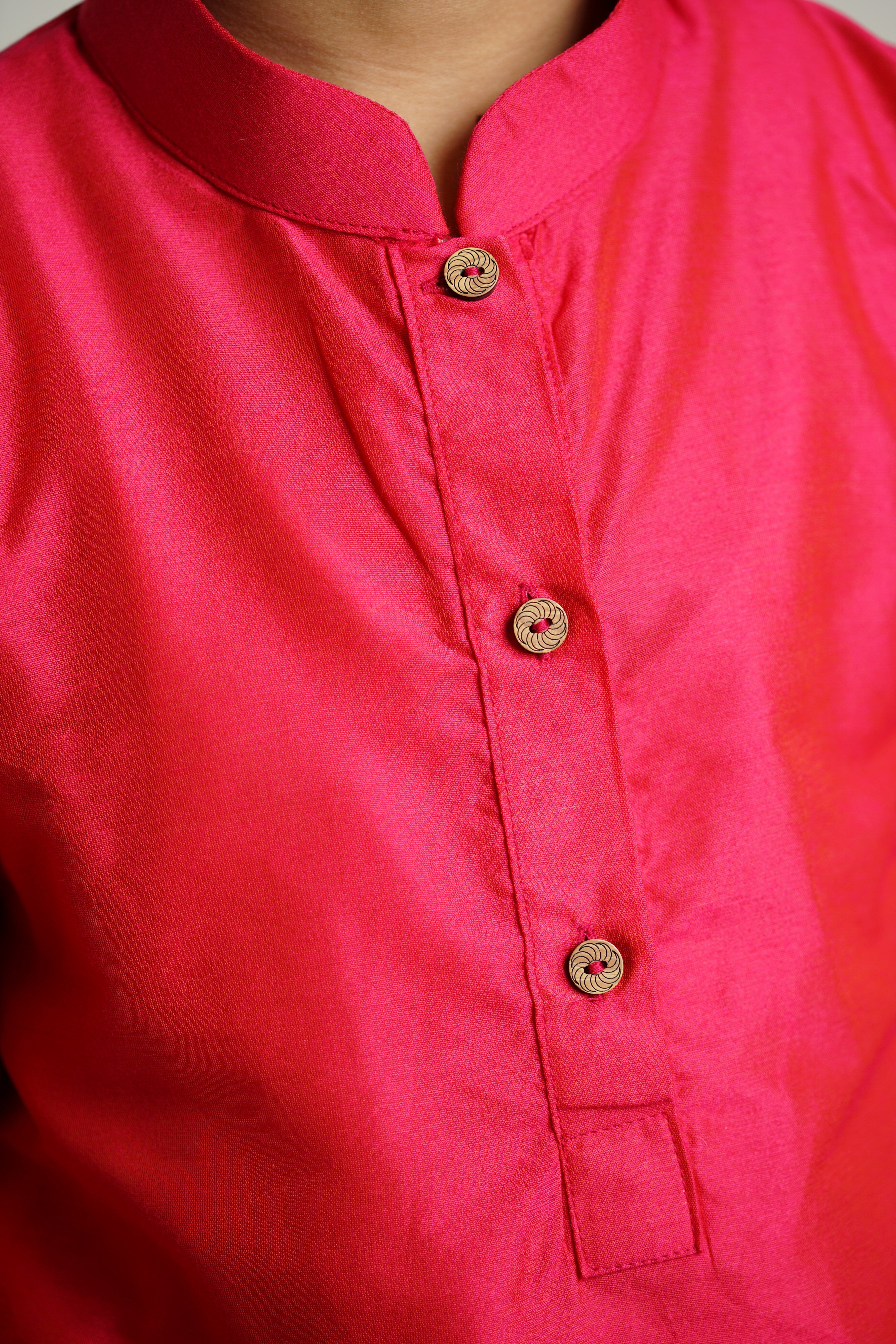 Fuchsia (dark pink) cotton silk stand collar long kurta with wooden buttons.Kurtas with collar or Angrakha pattern teamed with salwar are the best choice for any festive occasion for boys.They are Trendy, Easy to wear and comfortable to carry.