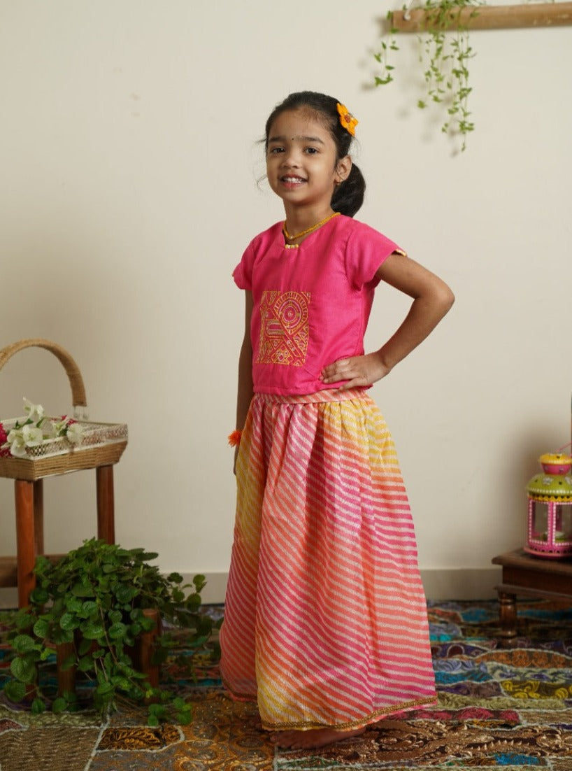 Yellow - Pink leheriya kotta elasticated long skirt with hot pink cotton silk crop top.Let your princess be as comfortable as in her casuals with carefully designed & crafted Comfort Ethnic Wear by Soyara Ethnics.Keep her fashion quotient high with timeless patterns, vibrant combinations and royal textiles.