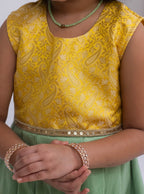 Introducing our latest product: a stunning yellow banarasi brocade yoke paired with a mint green raw silk pleated dress, complete with a delicate sequined lace waist detailing, designed specifically for girls. With its intricate craftsmanship and elegant color combination, this dress is sure to make a statement. Don't miss out on this unique addition to our collection!